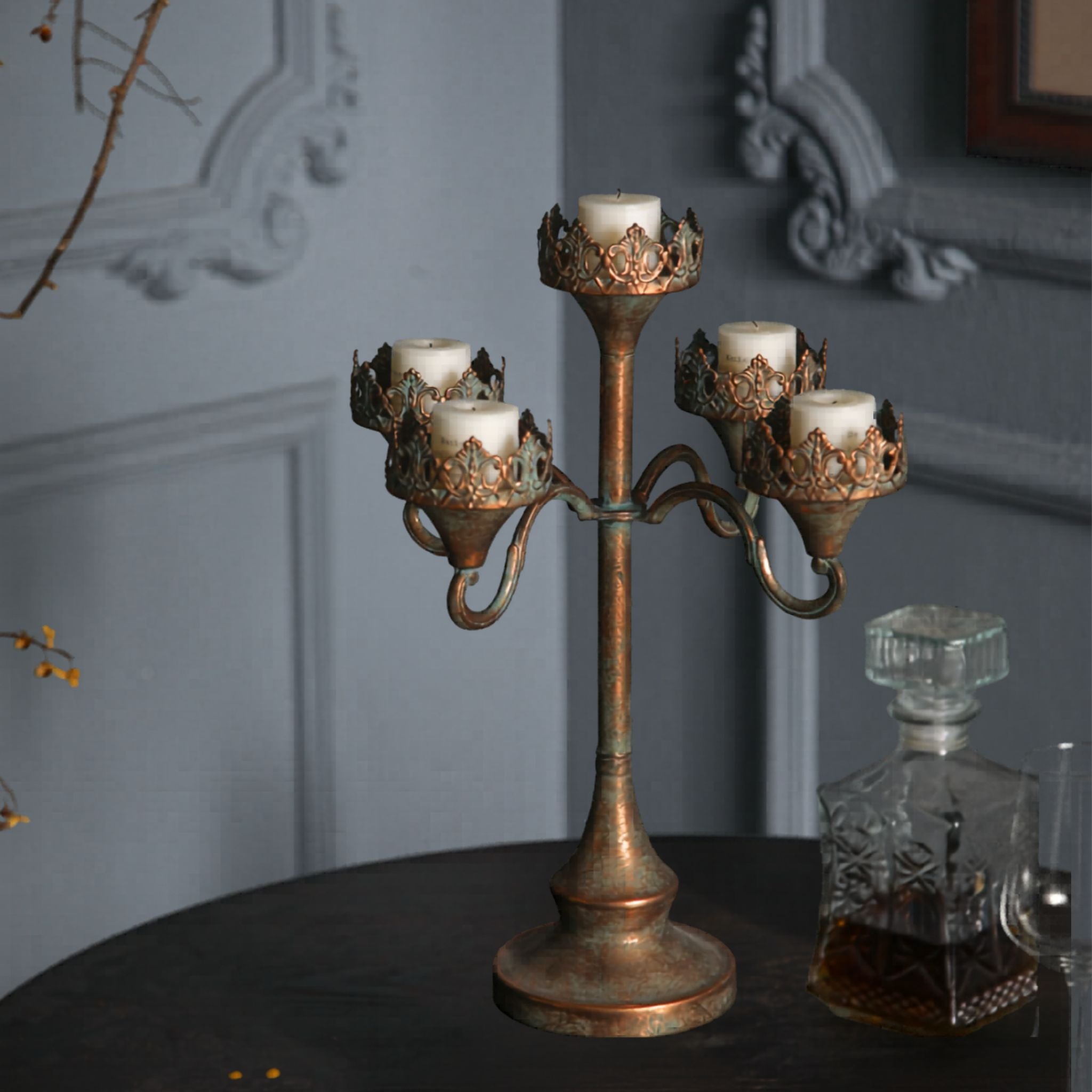 Corrine antique gold five-light candelabra, unlit cream pillar candles, showing the stepped arms and crown collars.