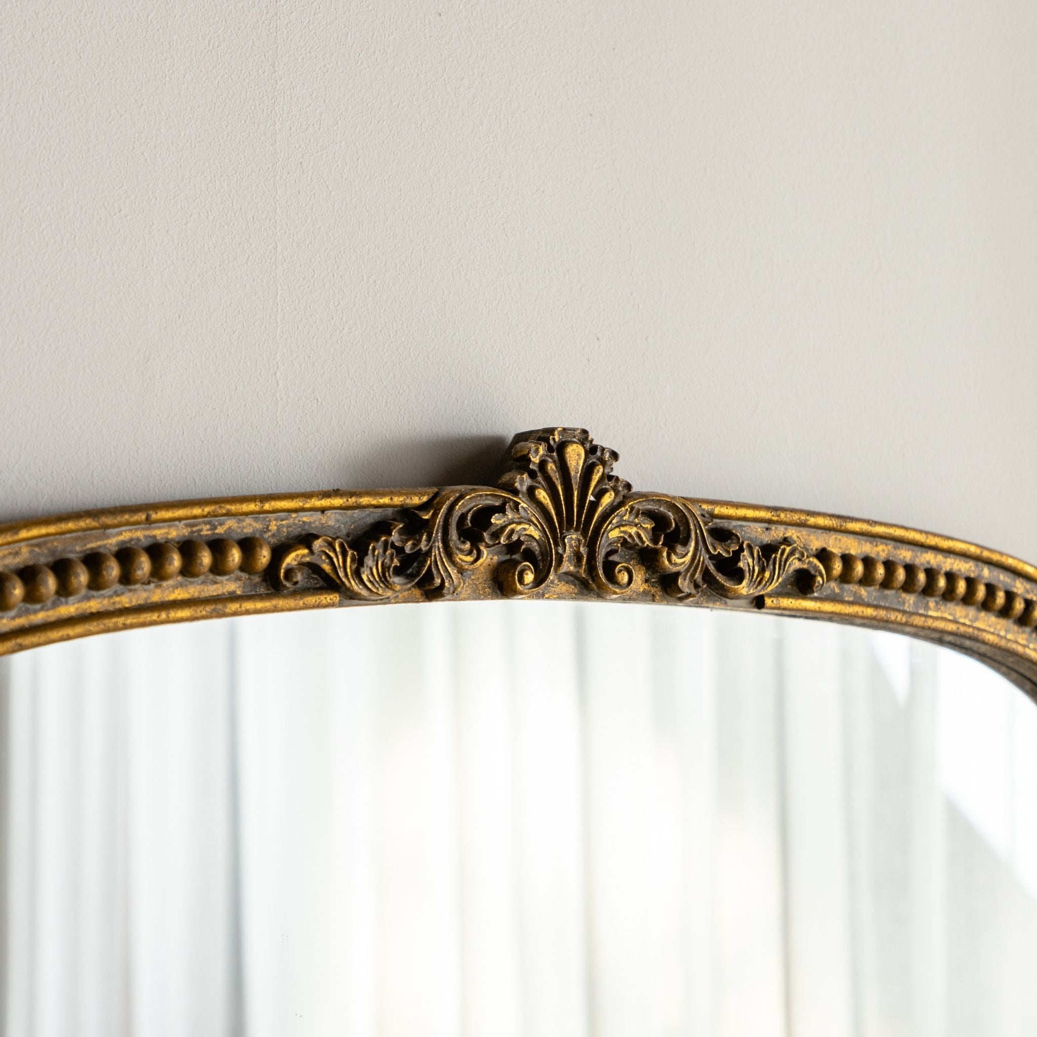 Renata arched mirror foliate crest close up in aged gold