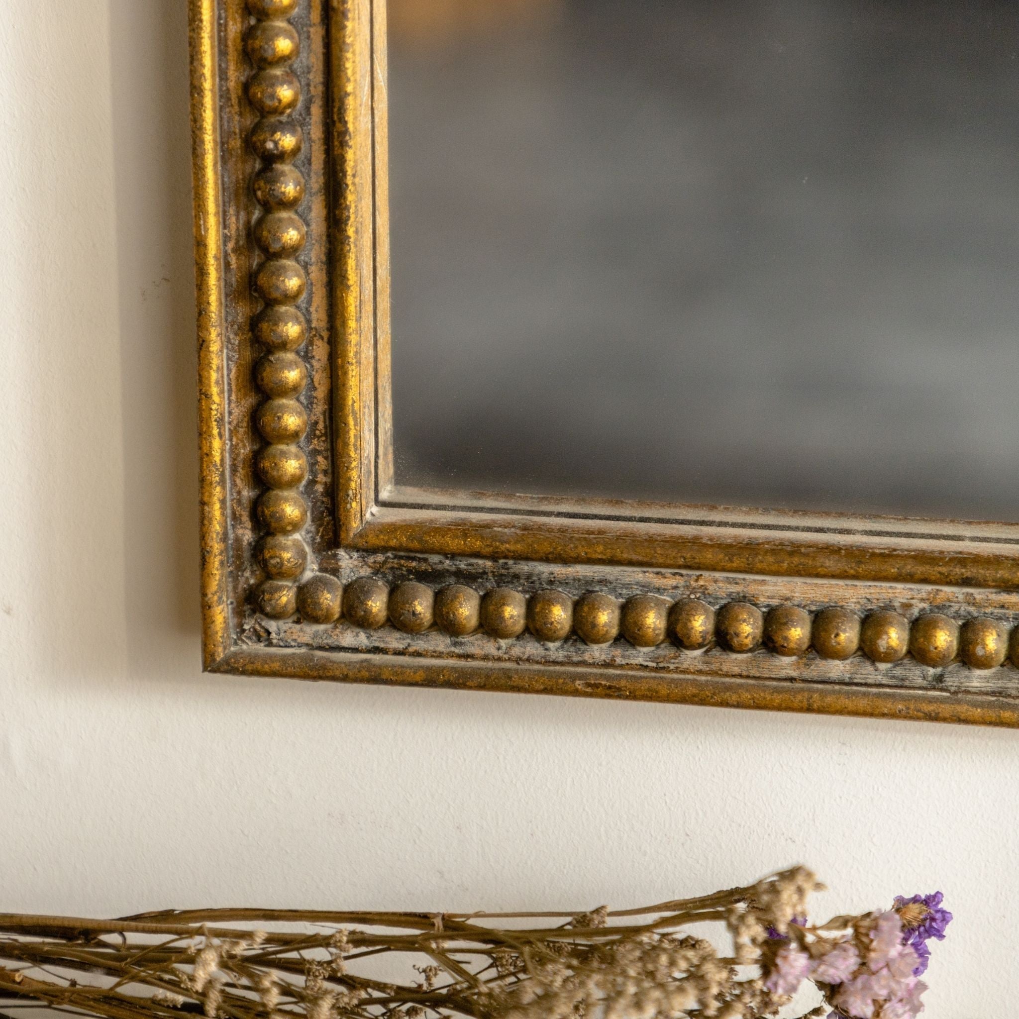 Renata mirror beaded frame corner close up showing aged gold finish
