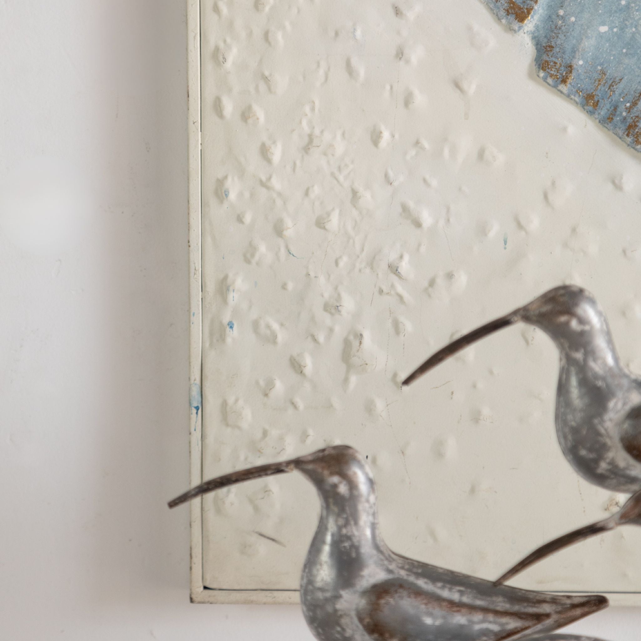 Close view of the embossed blue leaves and gold leafing on the Tino wall art