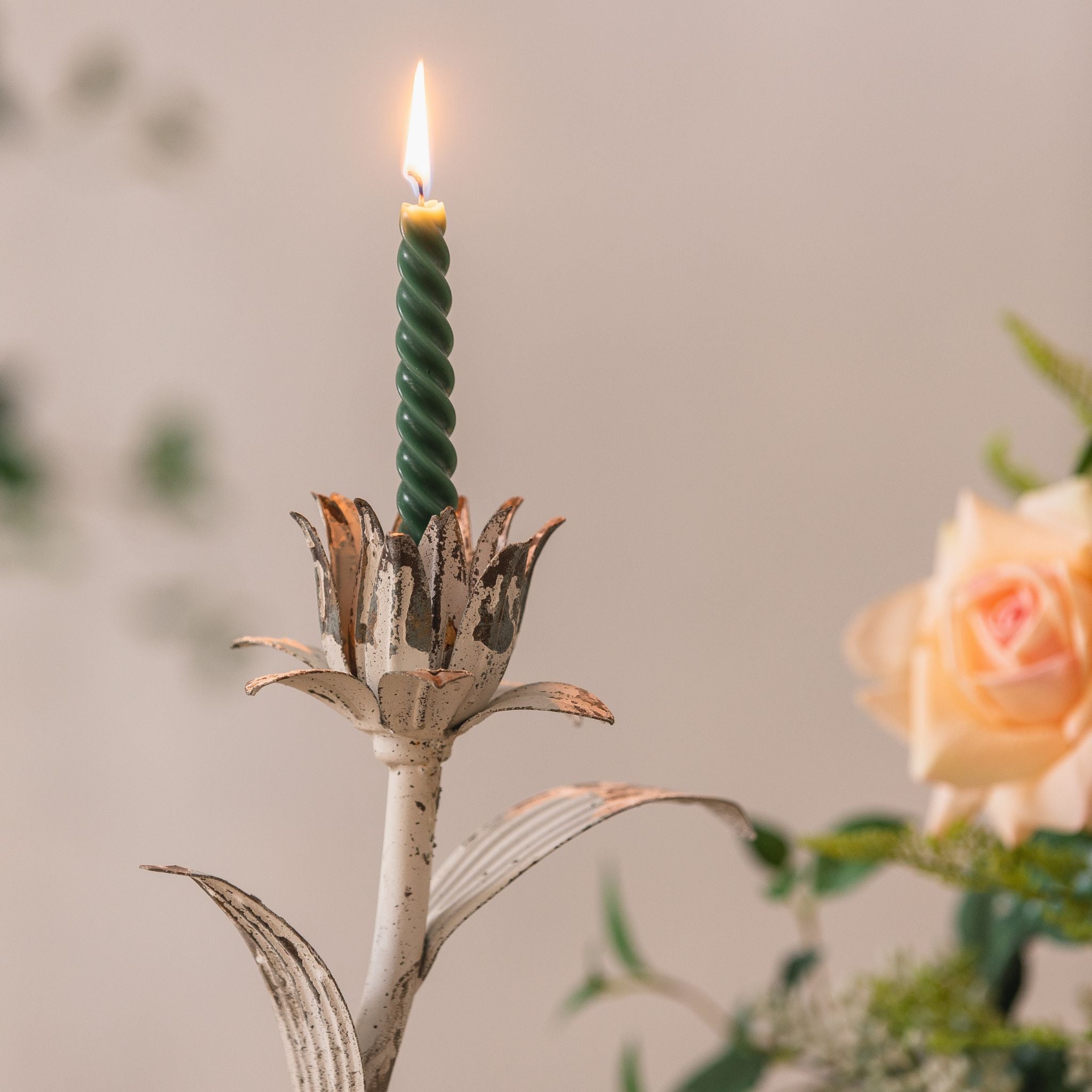 Siena iron flower candlestick with lit candle styled beside roses and an open book