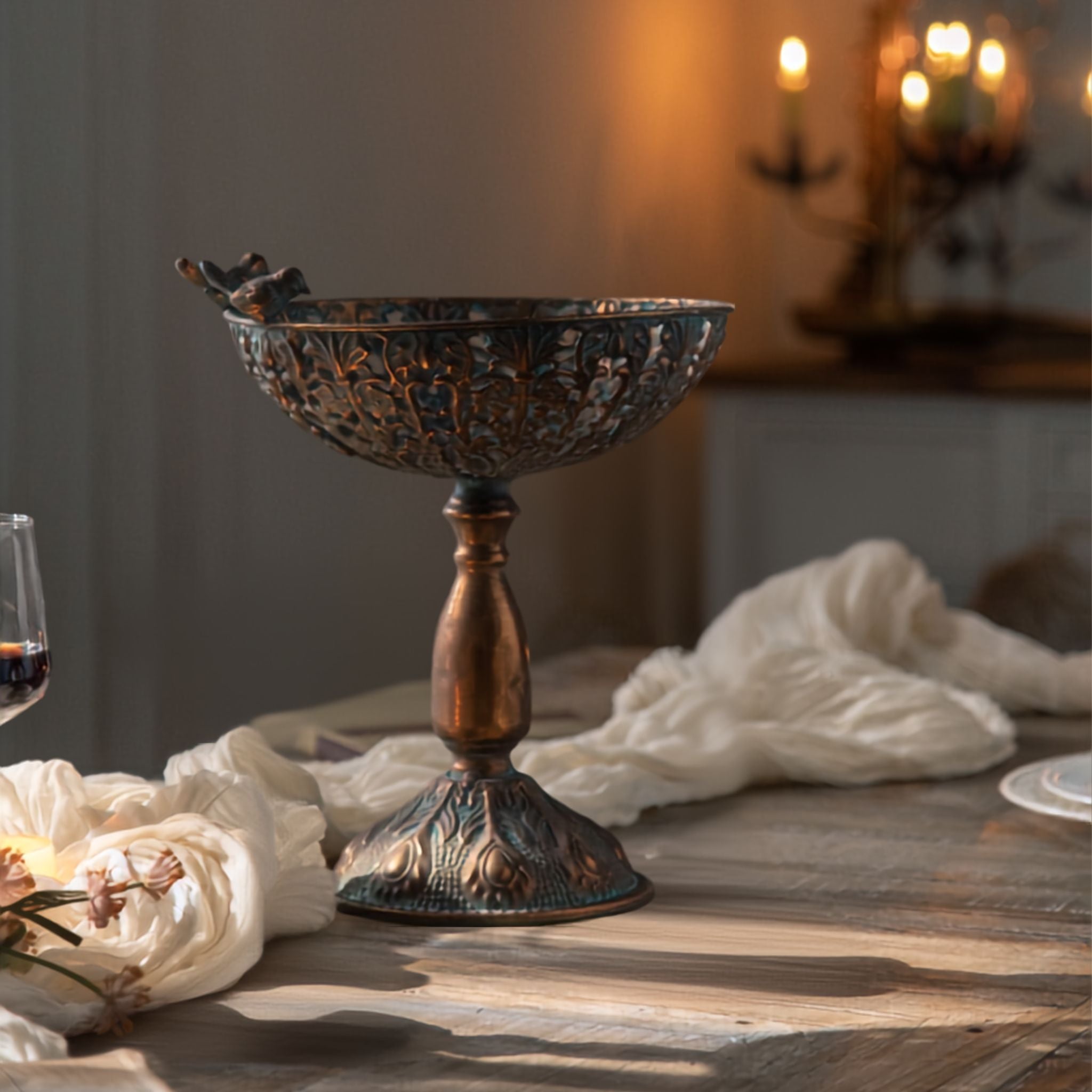 Santo large pedestal bowl in a bronze style finish with verdigris patina and a pair of birds on the rim