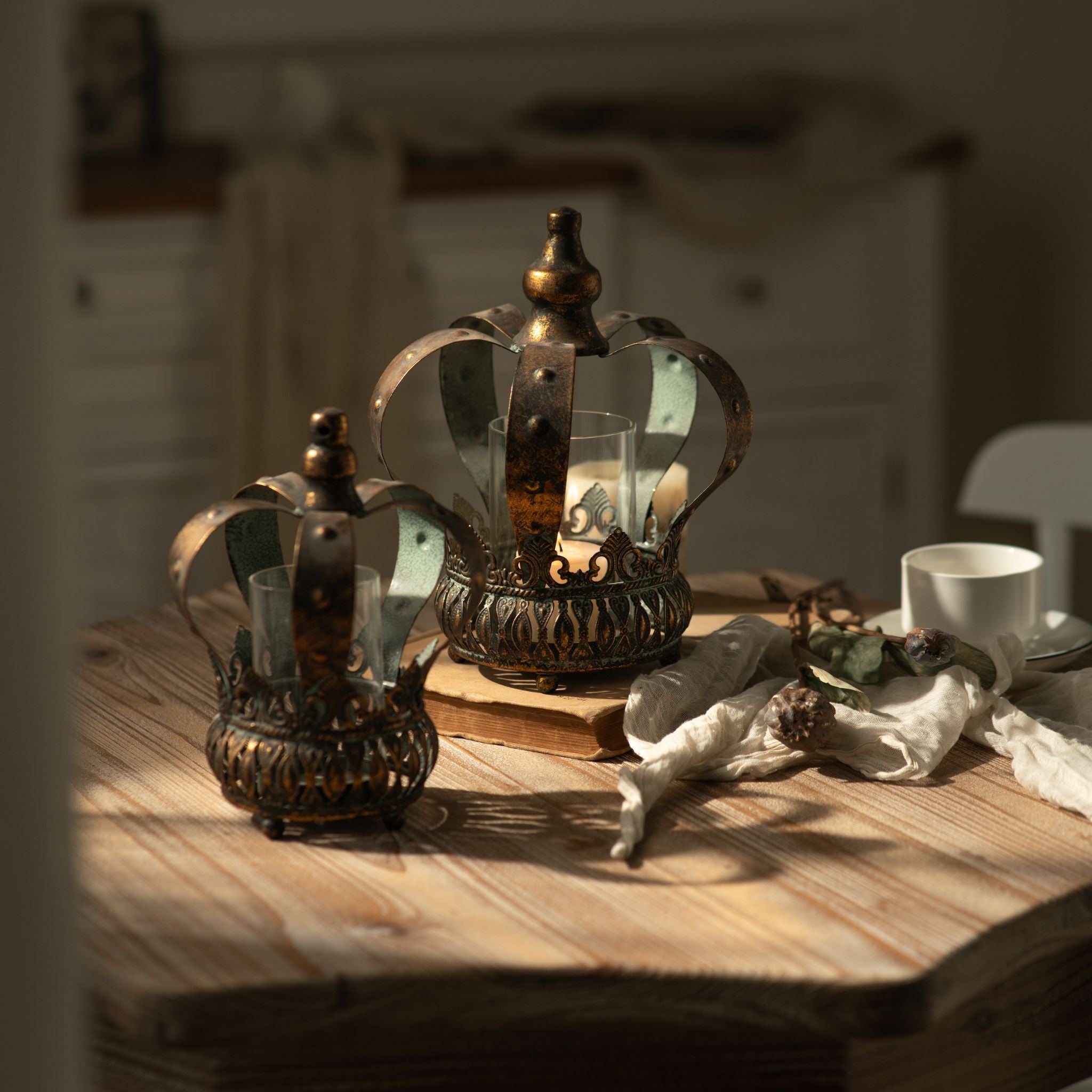 Close view of the large Rhodes crown candle holder with lit candle inside the glass sleeve