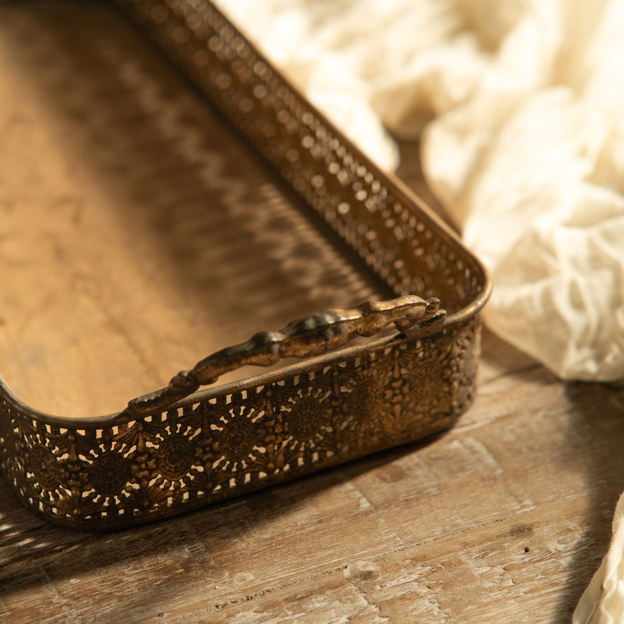 Ravello filigree trays stacked on a dining table with wine and plates
