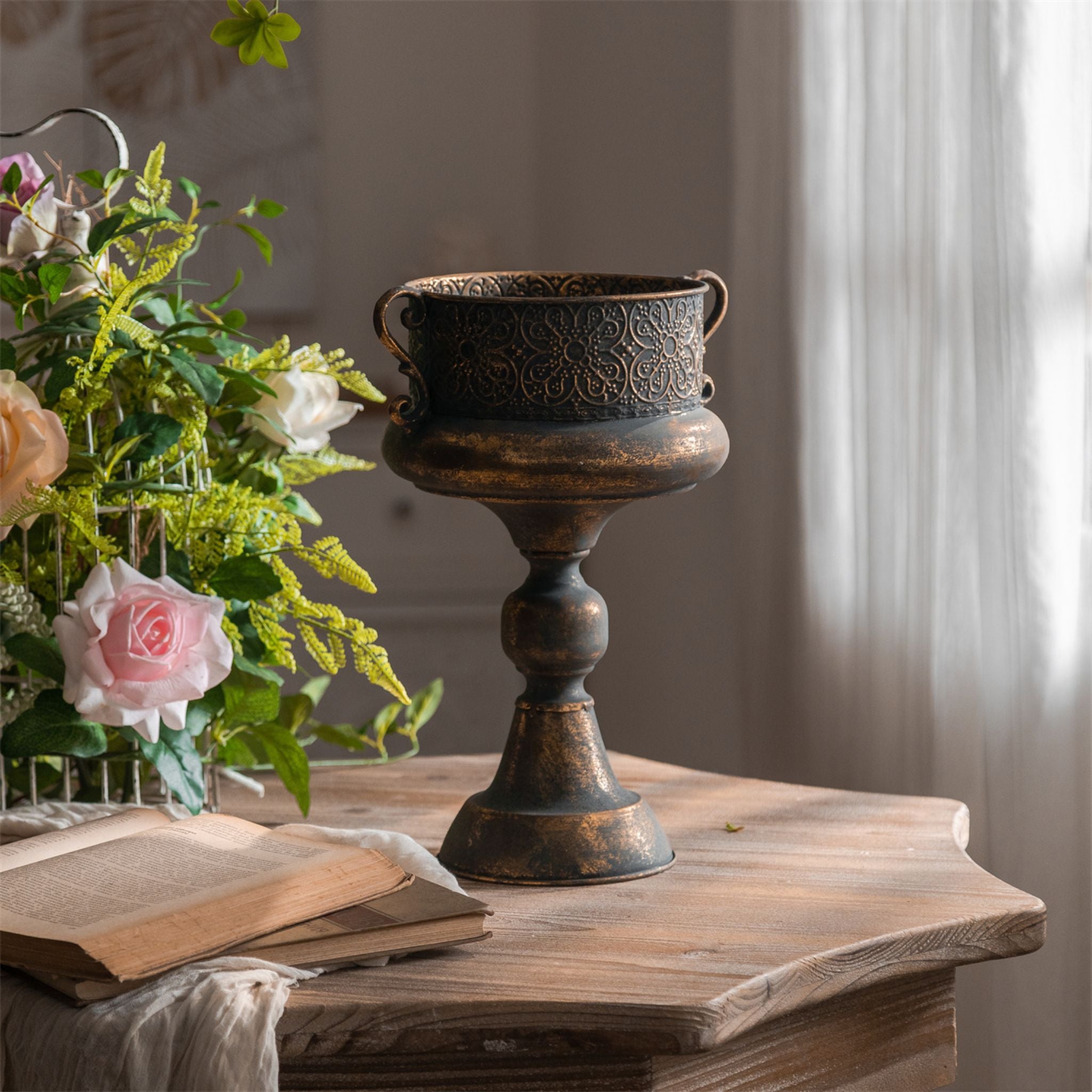 Arles urn planter in an aged bronze finish with embossed floral band and scroll handles