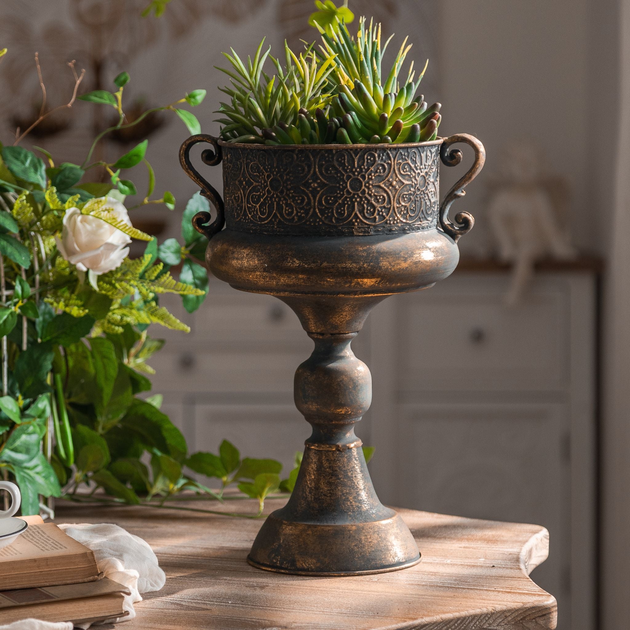 Close view of the embossed floral band and scroll handle on the Arles urn planter