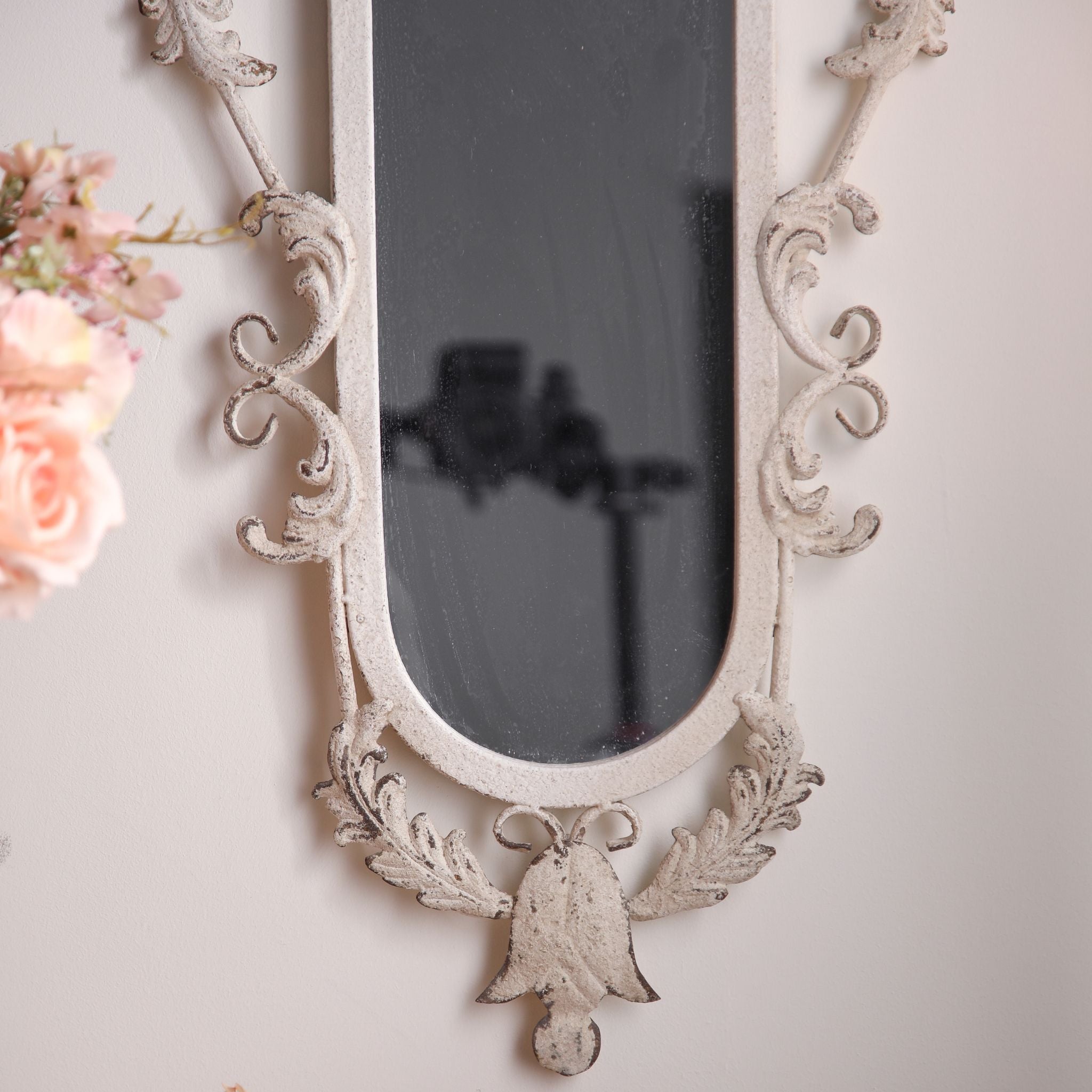 Close view of the acanthus scrolls and worn white finish on the Pilar mirror frame