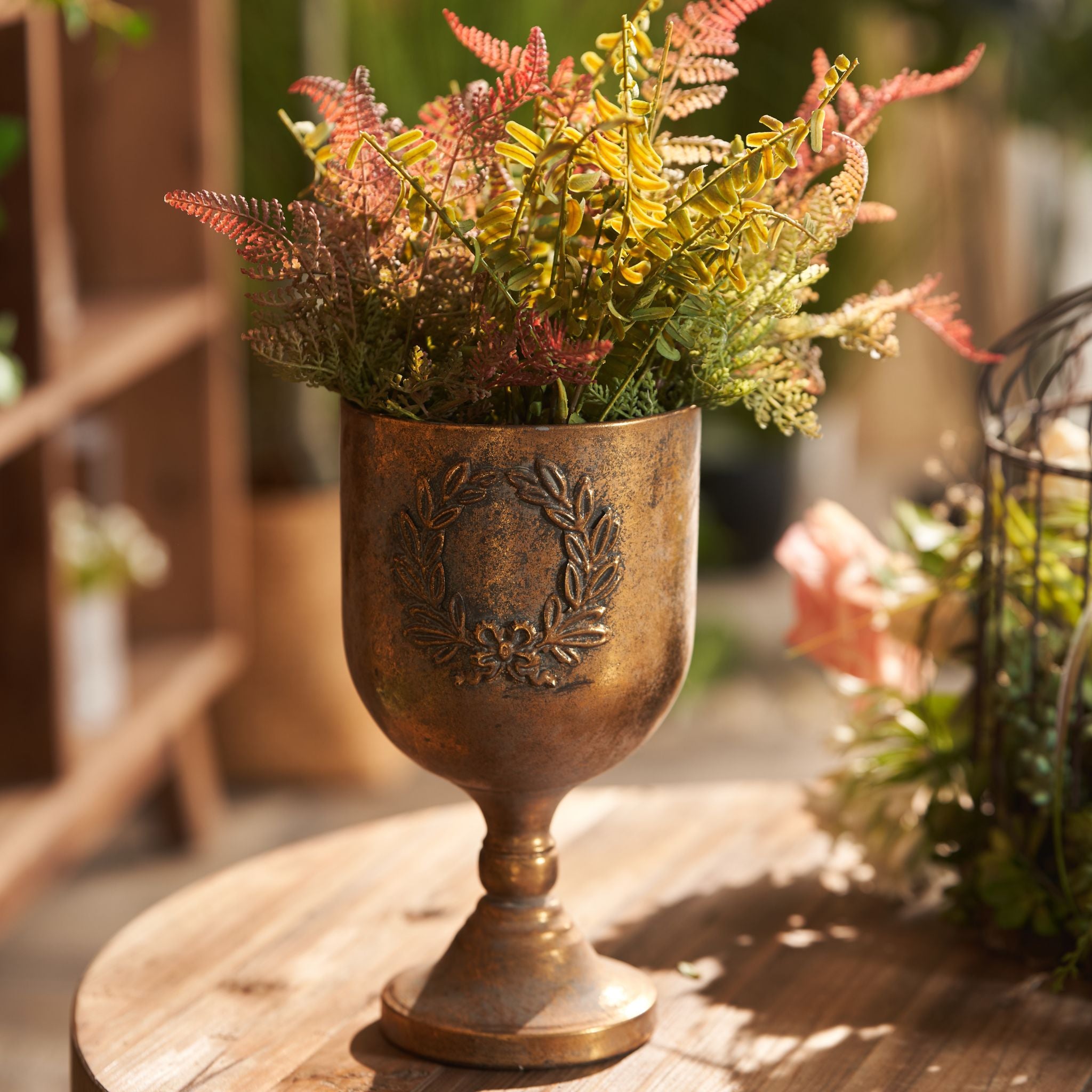 Norma goblet urn in warm light showing the mottled antique gold patina