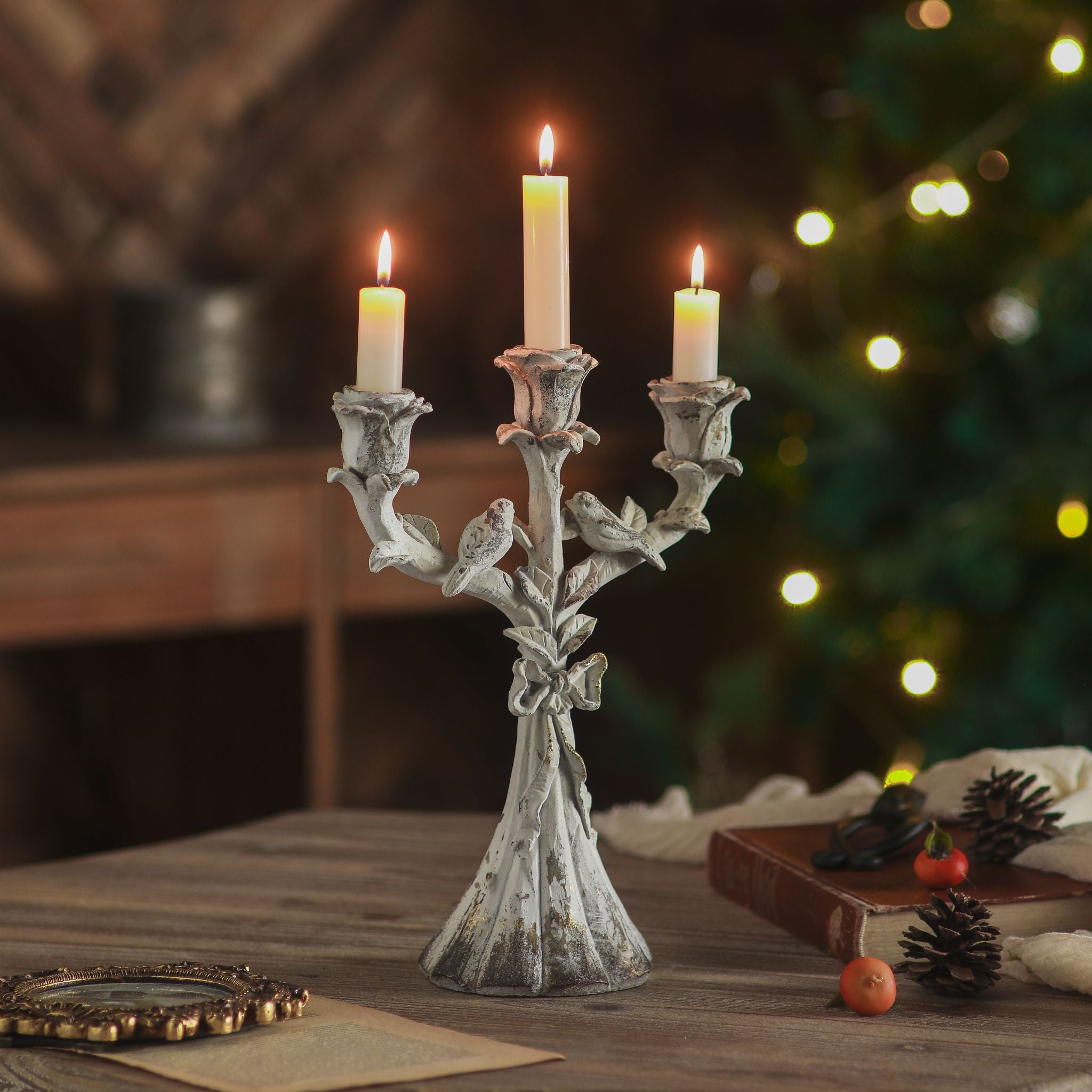 Corfu rose candelabra in distressed white with three lit tapers on a festive table