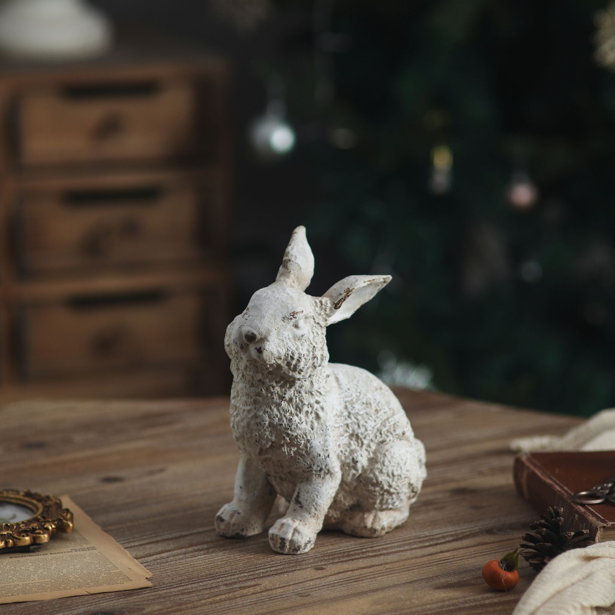Dante rabbit sculpture in aged white with textured coat sitting on a timber table