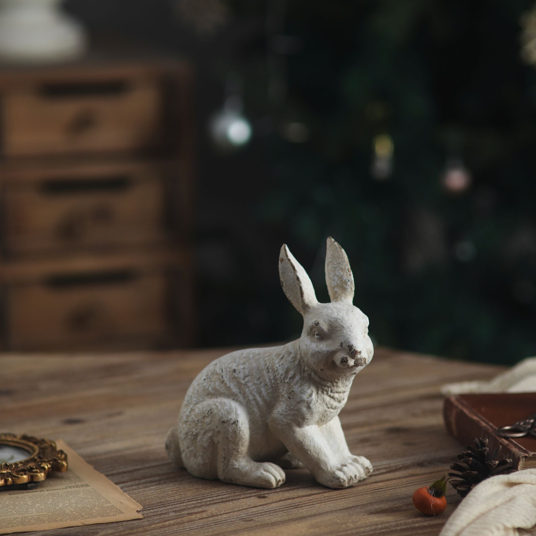 Delos sitting rabbit sculpture in aged white on a timber table