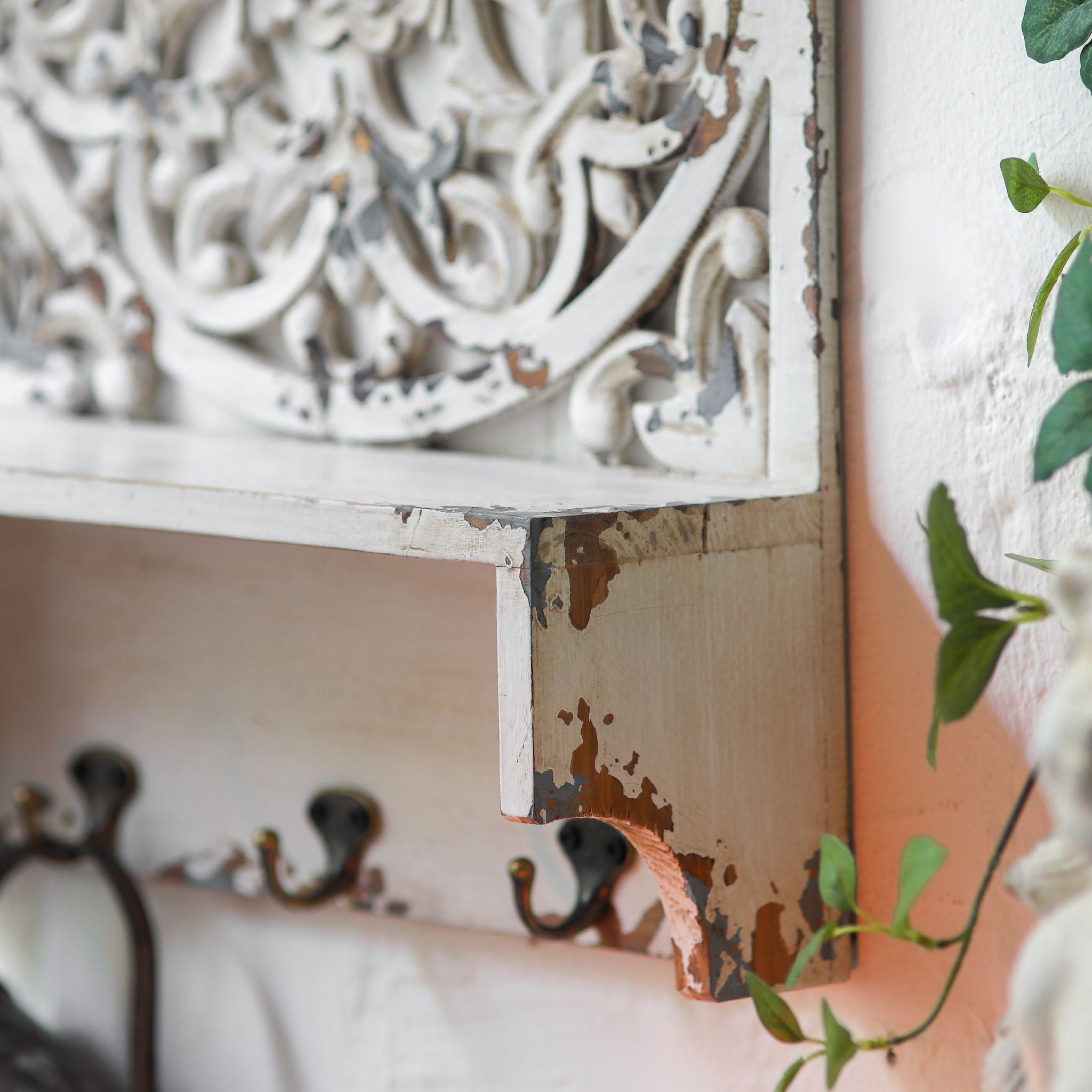 Close view of the pierced arch carving on the Dimitri wall shelf showing chipped white finish over grey and gold