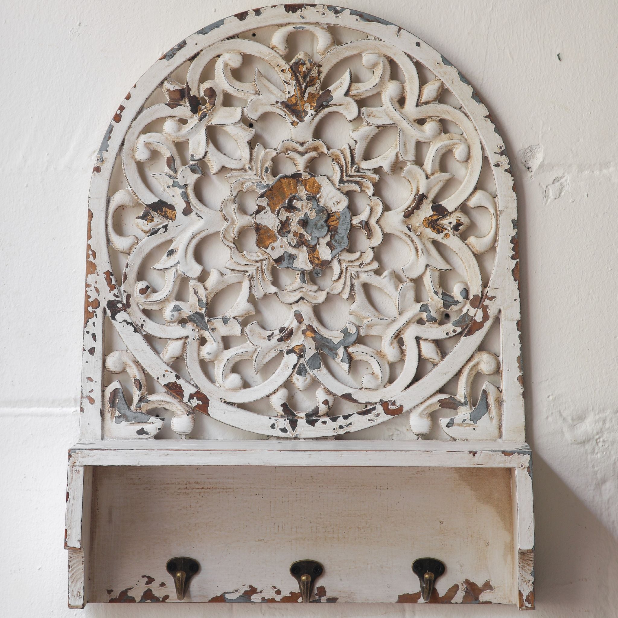 Dimitri arched wall shelf styled on a wall with decor on the shelf and hooks in use