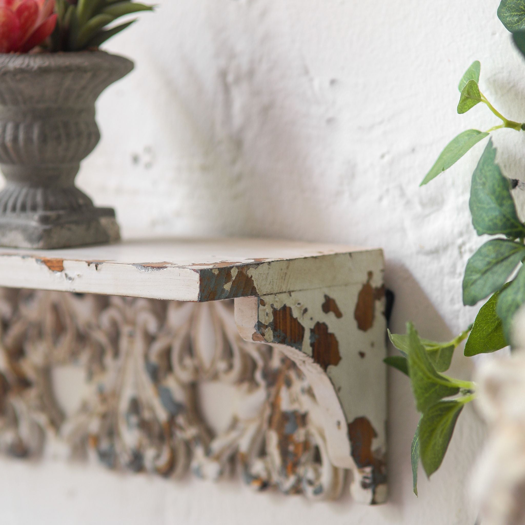 Side view of the Elias wall shelf corbel end with chipped paint detail