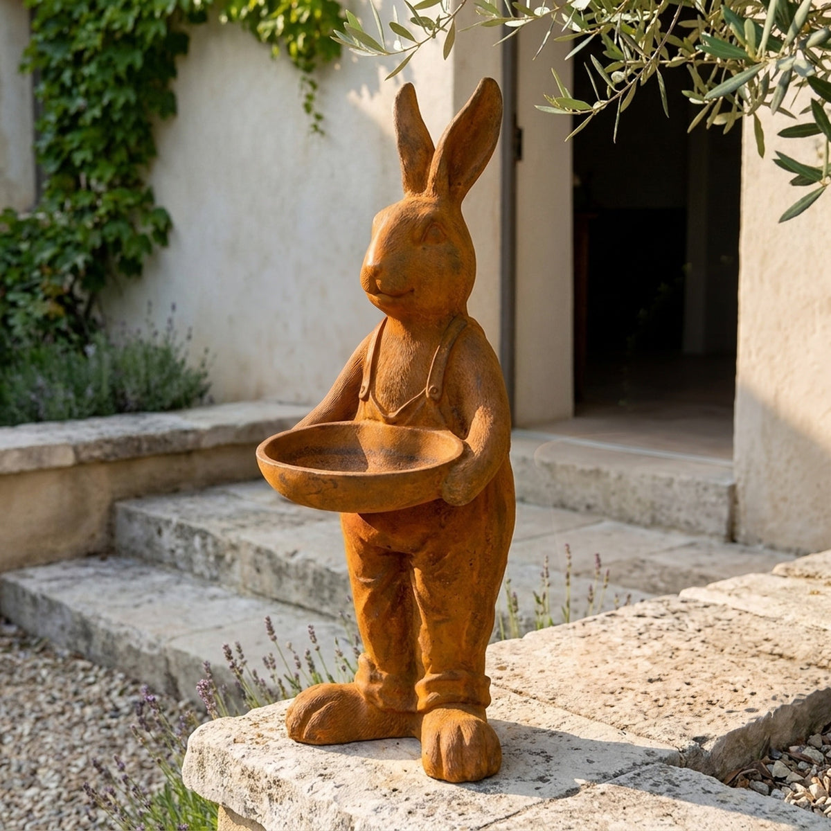 Farmer Barnaby hare statue bird feeder three quarter view in a provencal courtyard