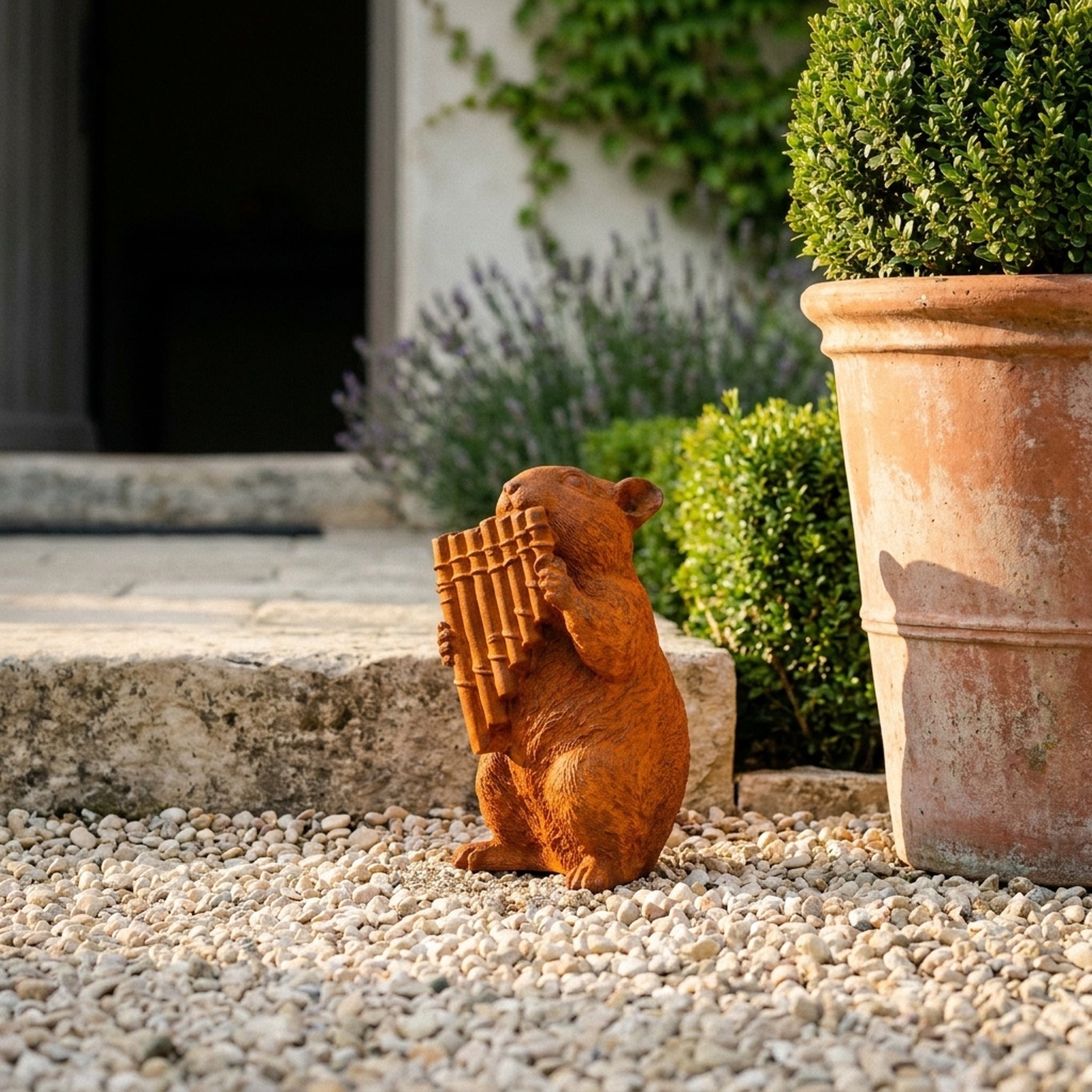 Archie dormouse statue with pan pipes three quarter view in a provencal courtyard