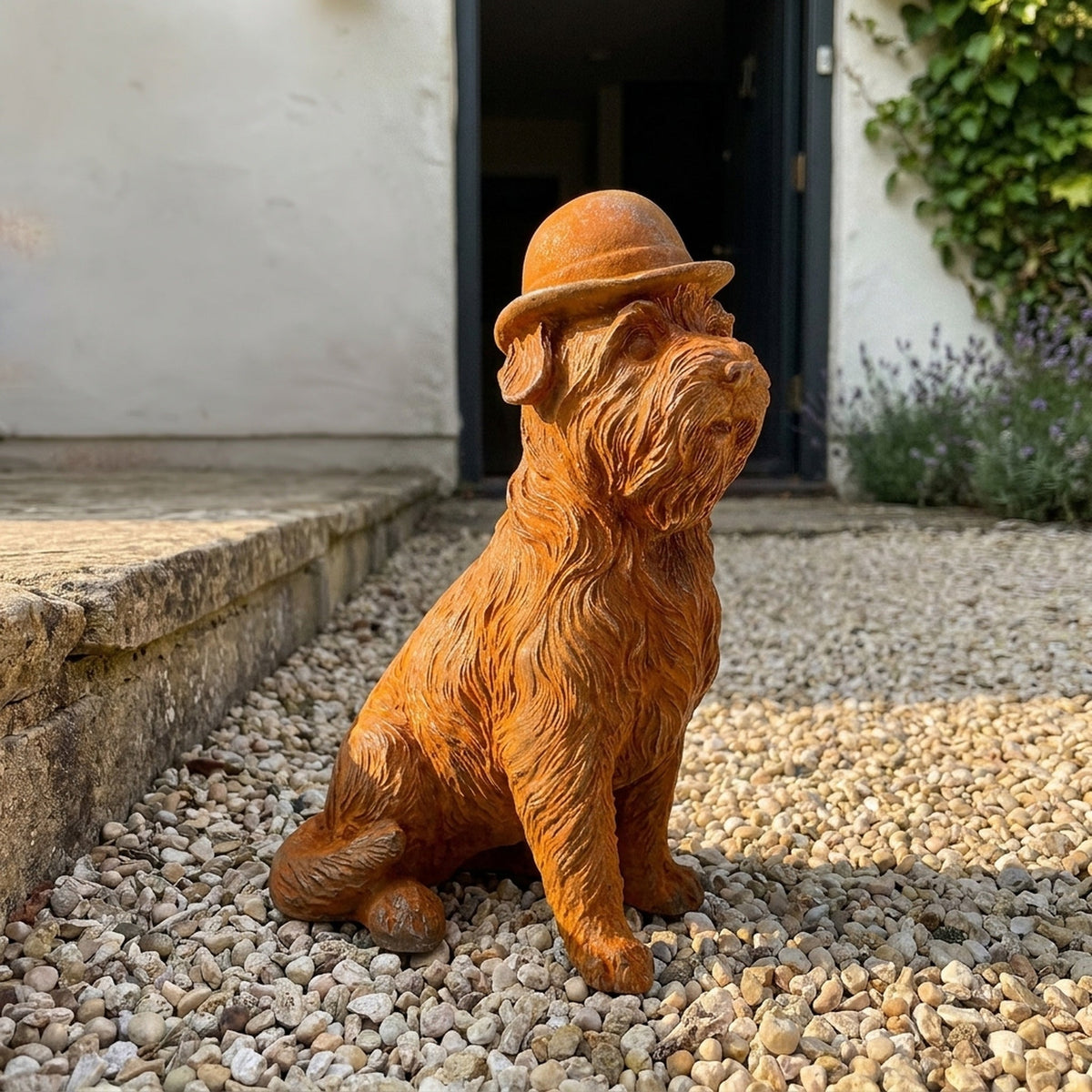 Mr Capone rust cast iron terrier statue in a bowler hat, on gravel