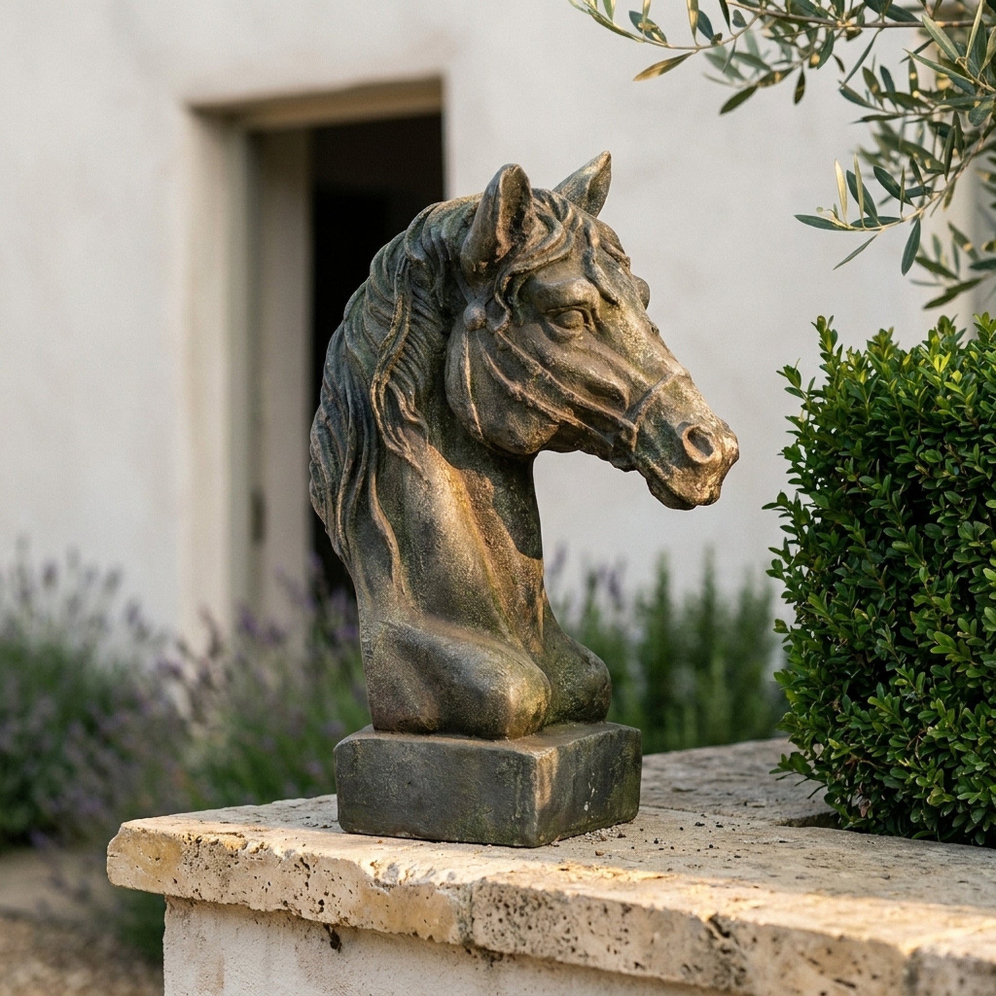 Duke Beaumont Antique bronze green horse head bust on a travertine garden wall with lavender and box hedging