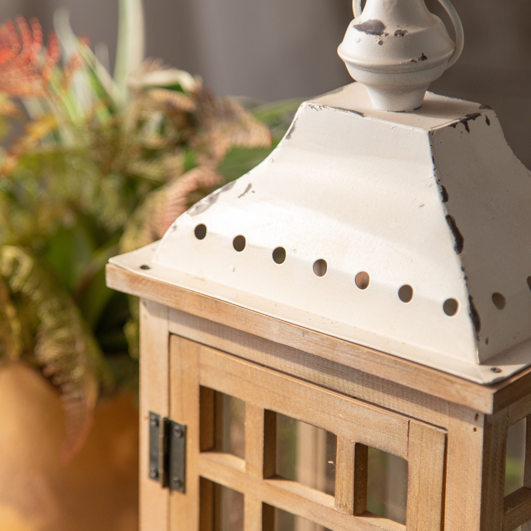 Close-up of the distressed white metal roof with ring finial and vent holes