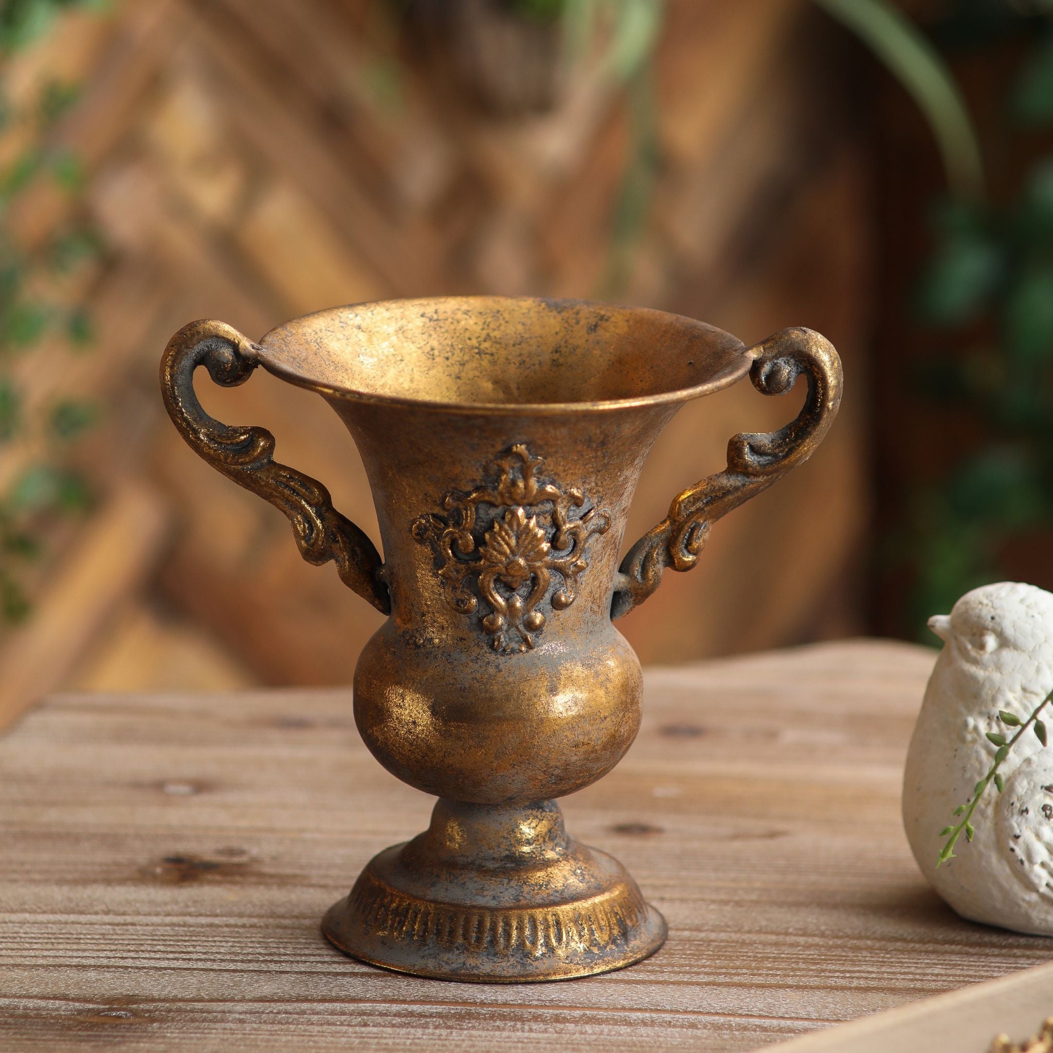 Lorenzo antique gold urn vase front view showing the raised medallion crest and scrolled handles