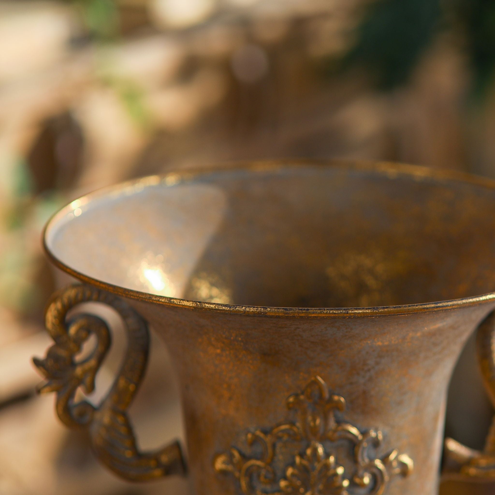 Capri urn vase close-up of the flared trumpet rim and rust-gold finish