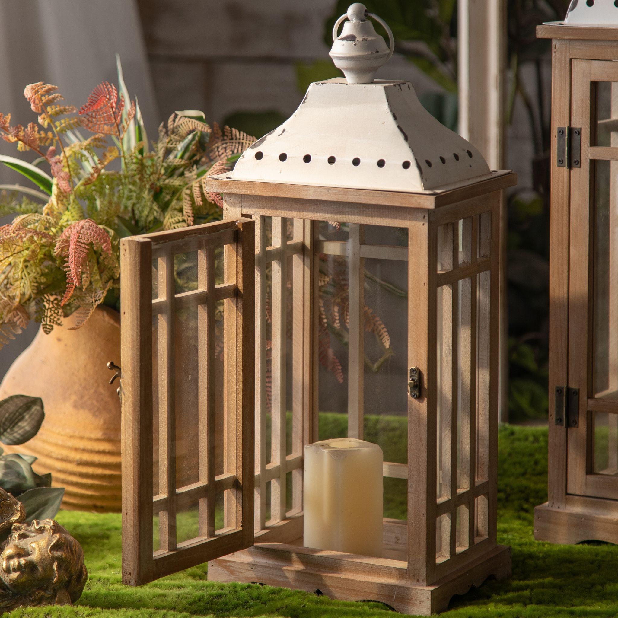 Wooden lantern with the glass door open and a pillar candle on the base
