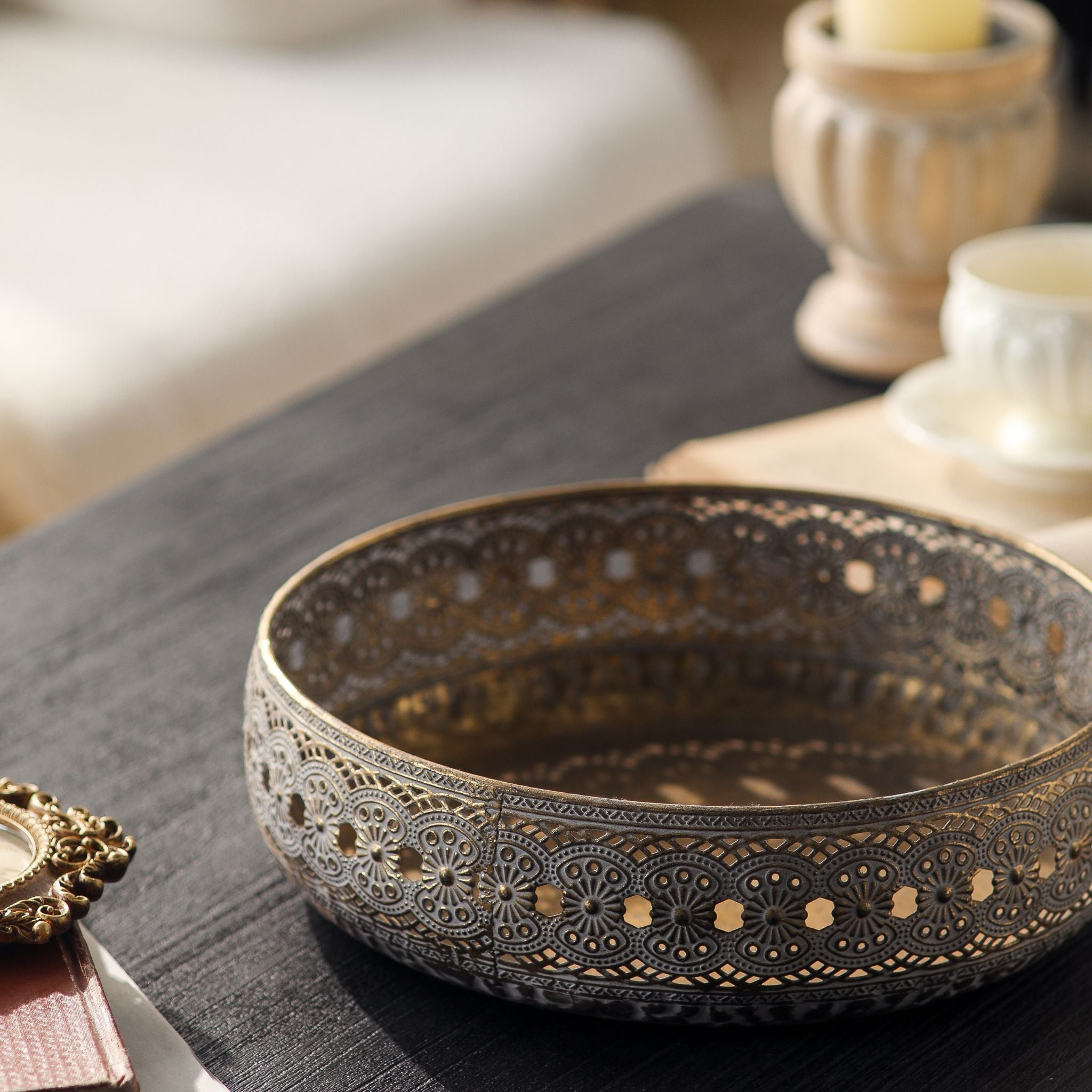Single Abrielle metal bowl front on, embossed floral band with a row of pierced openings around the wall