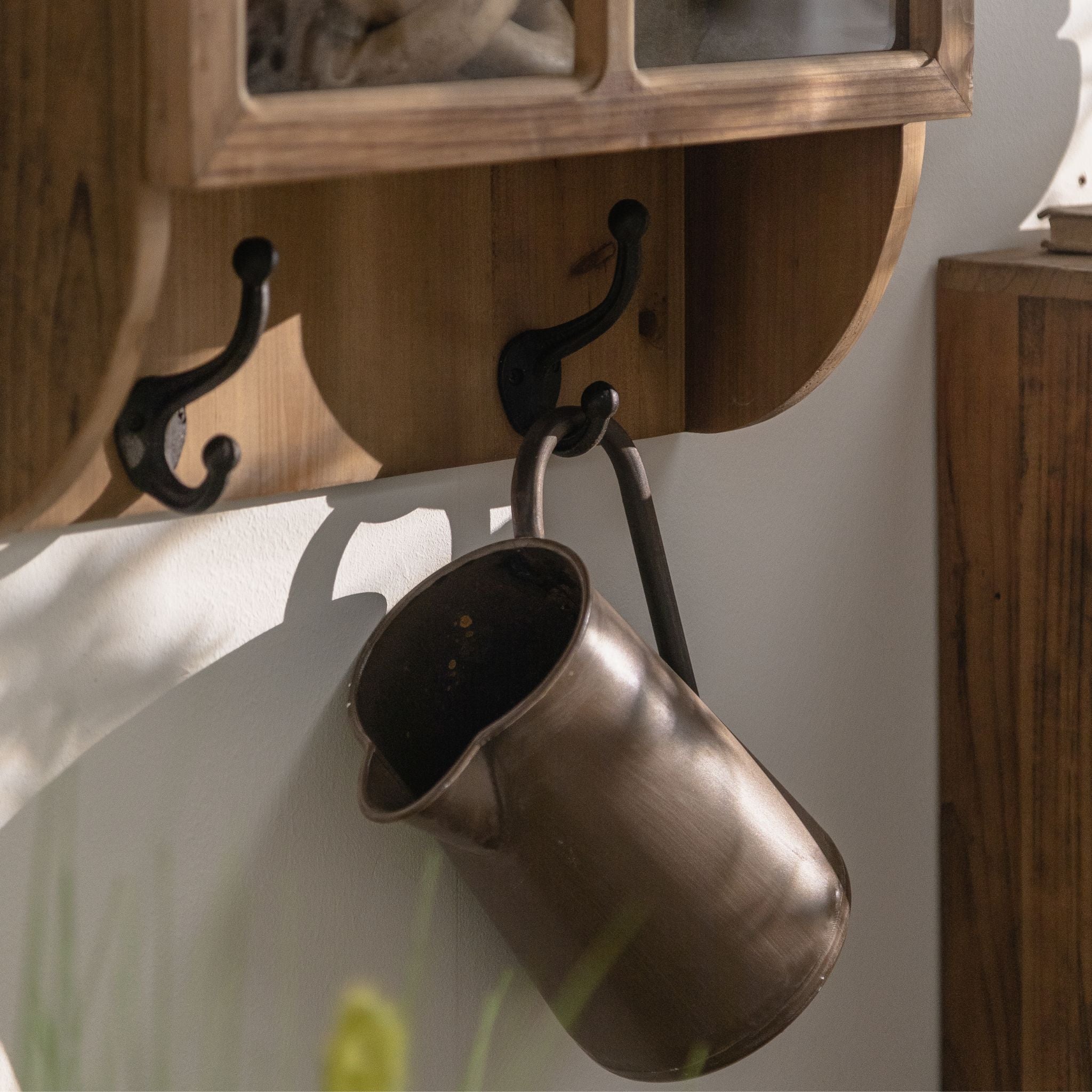 Alain wall cabinet, close detail of the two black cast-iron double hooks on the scalloped lower board.