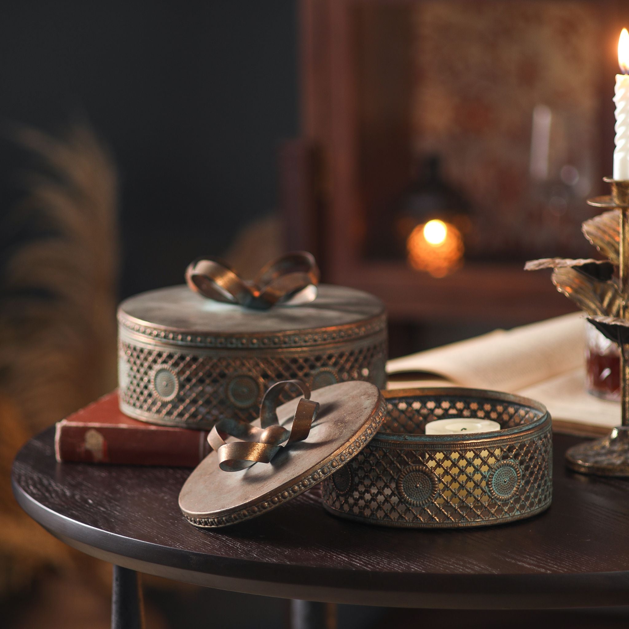 Alba boxes styled by candlelight, one open with a lit tealight glowing through the pierced sides.