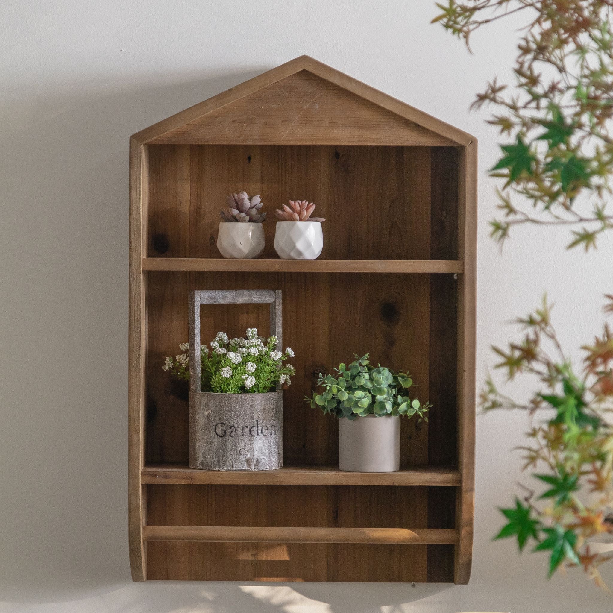 Alderic house-shaped wall shelf in natural pine timber, two open shelves with a gable top and a lower rail. Hero.