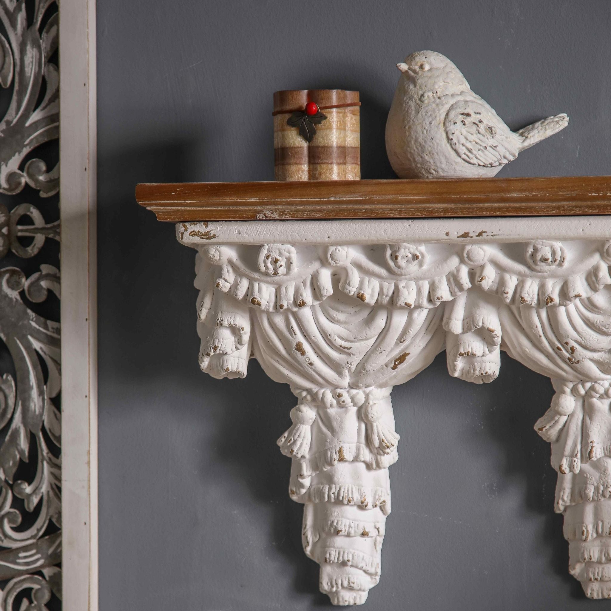 Close-up of Annie wall shelf showing the carved swag valance, scalloped tassel fringe, and curtain panel folds