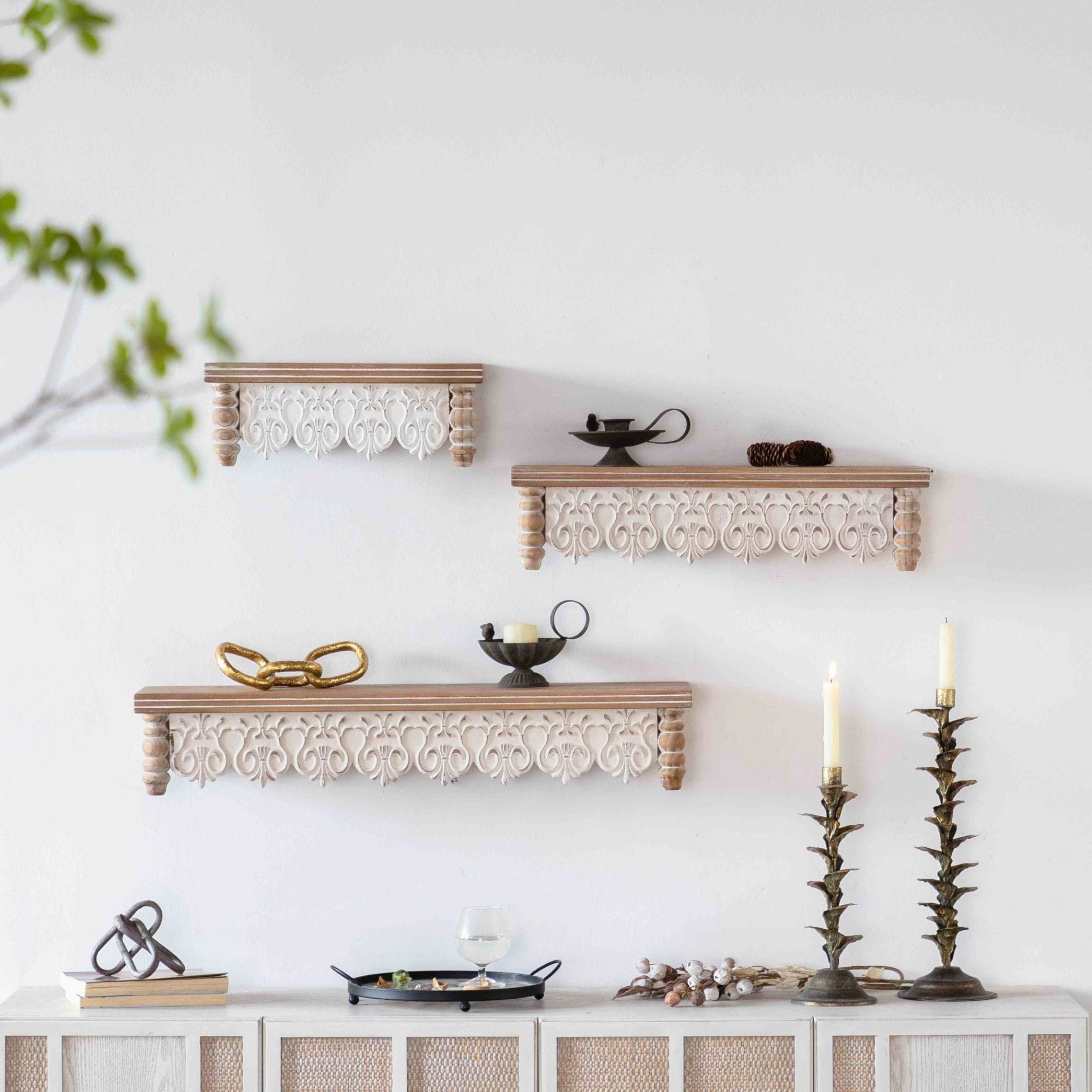Ariane wall shelf, the largest of three carved-apron shelves, shown as a stepped set on a wall.