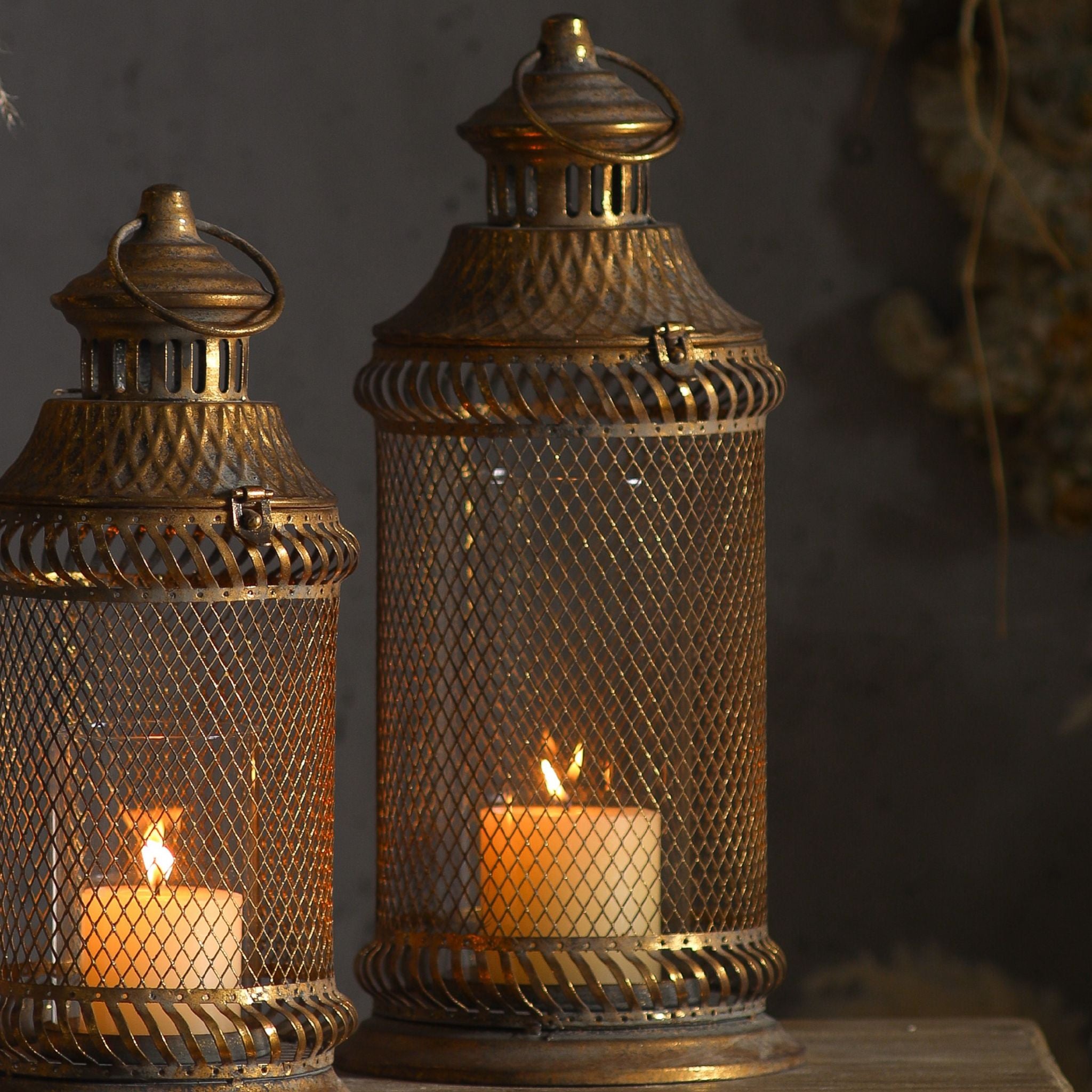 Close detail of the Arielle lantern showing the diamond mesh, removable glass sleeve, domed top, ring handle and braided antique gold bands.