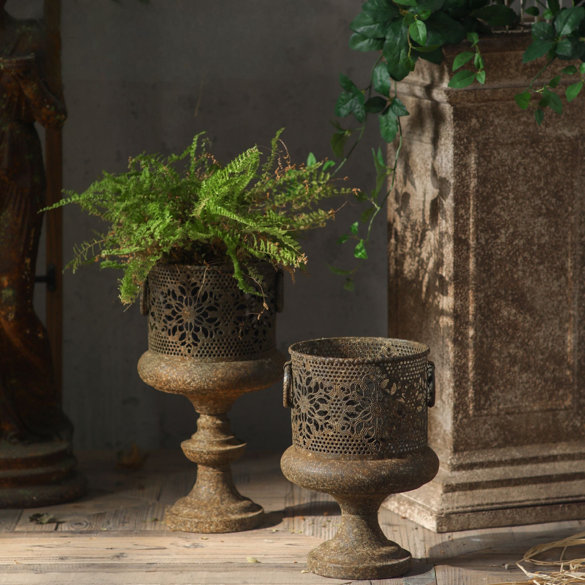 Arthur pedestal planter, taller size at left with a fern, shown alongside the smaller size