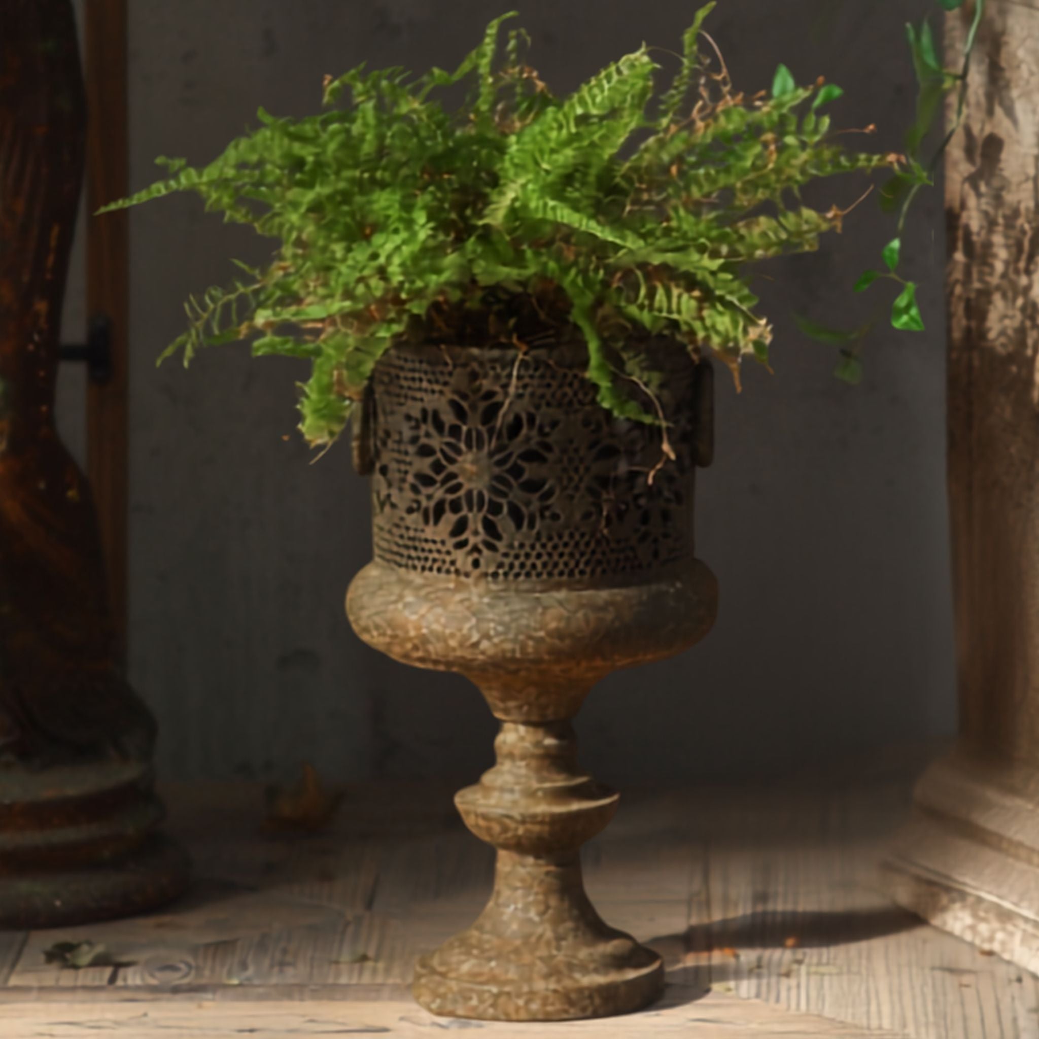 Arthur aged metal pierced pedestal planter, the taller size, planted with a fern. Hero.