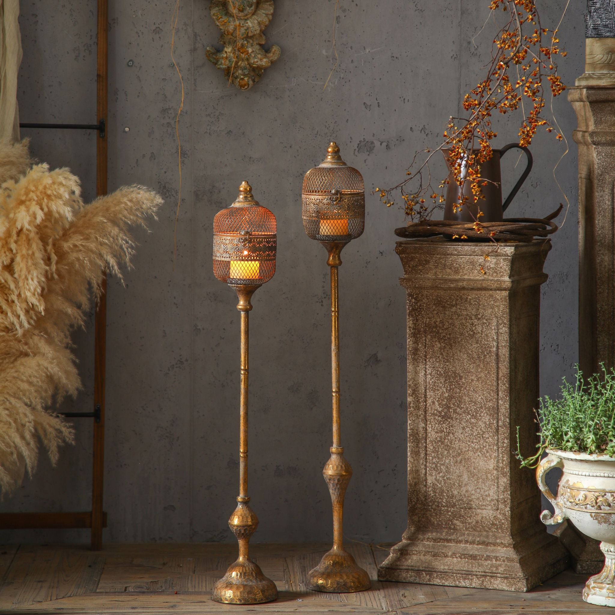 Astrid floor lantern, shorter on the left, shown beside the taller Celine lantern, both lit. Sold separately.