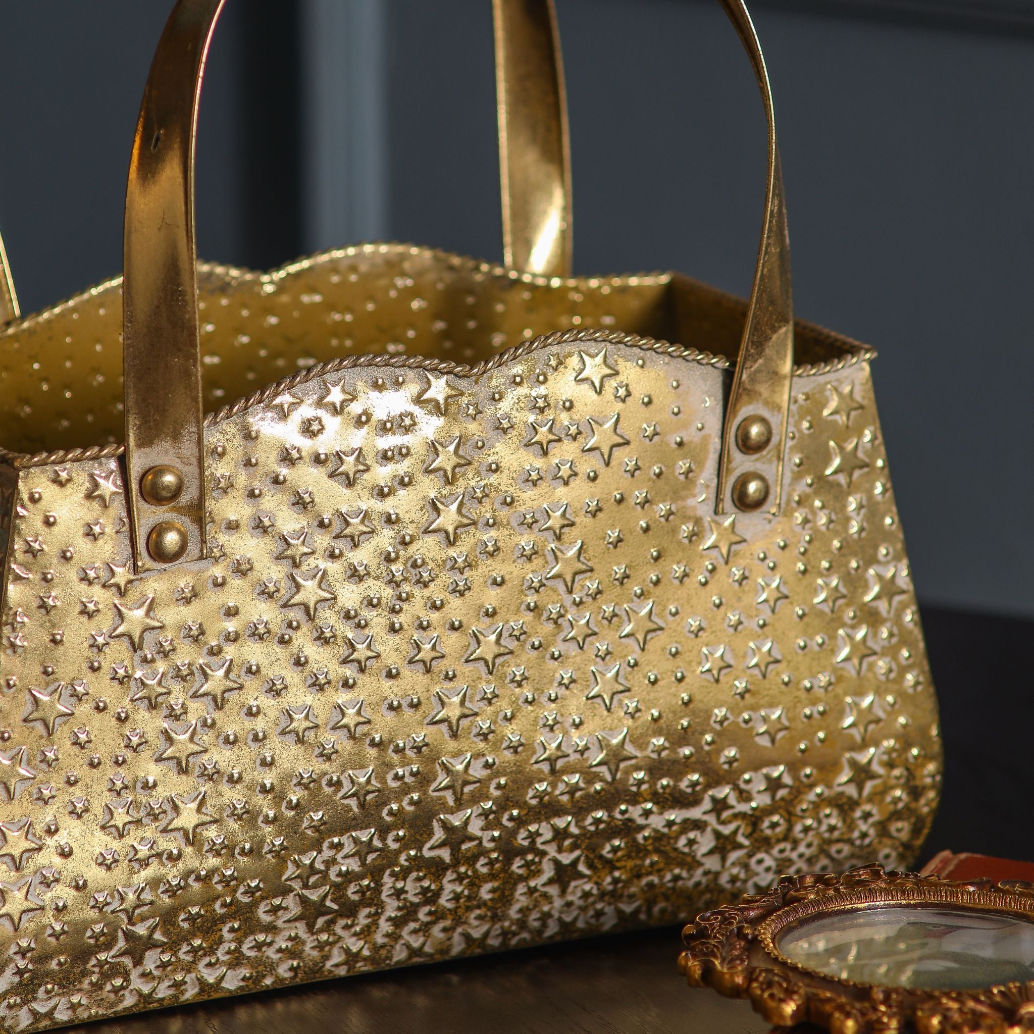 Open top of the gold handbag planter showing the star-embossed metal and twisted rope rim