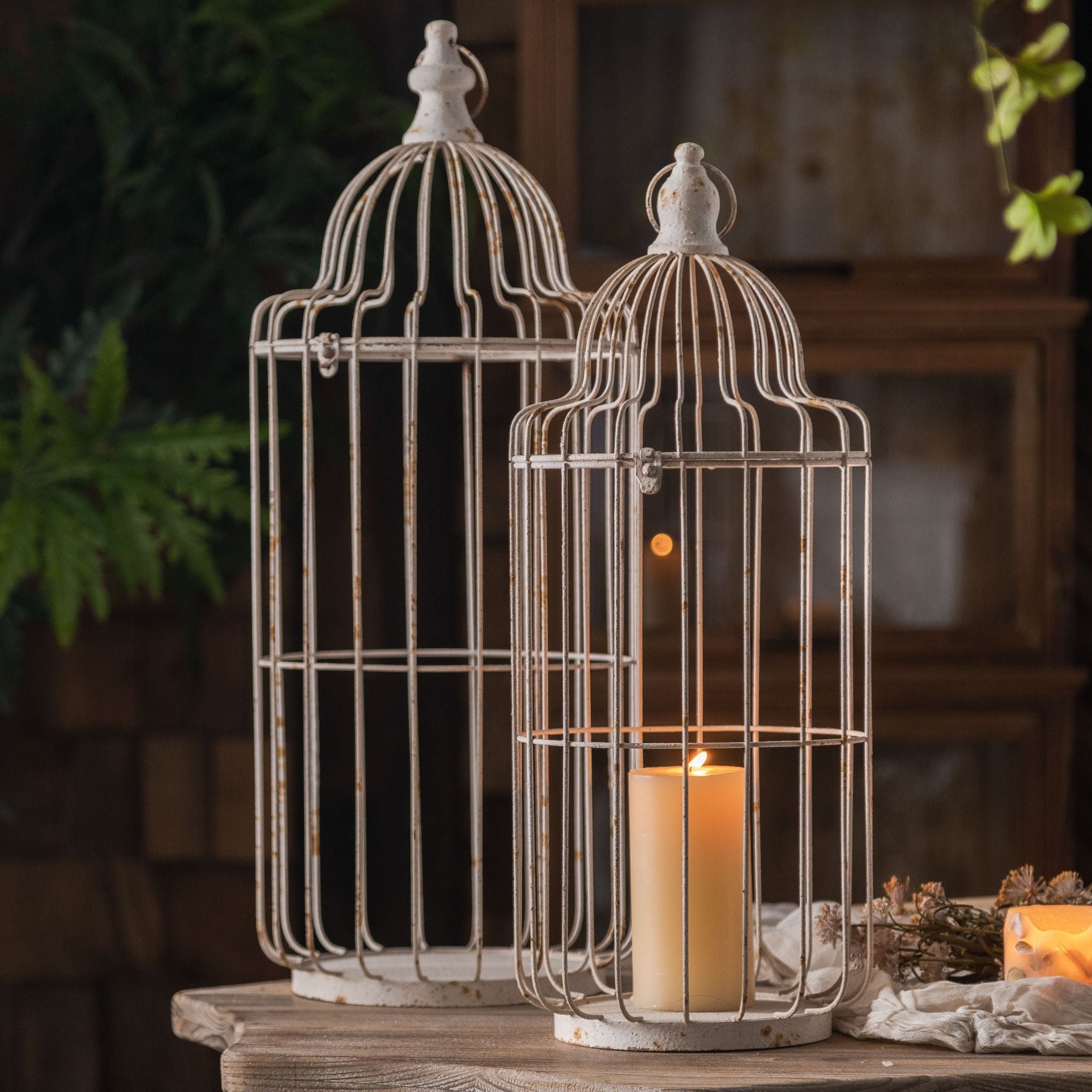 Bernard French Provincial birdcage candle lantern set of 2, antique white aged metal pair on rustic console with lit candle