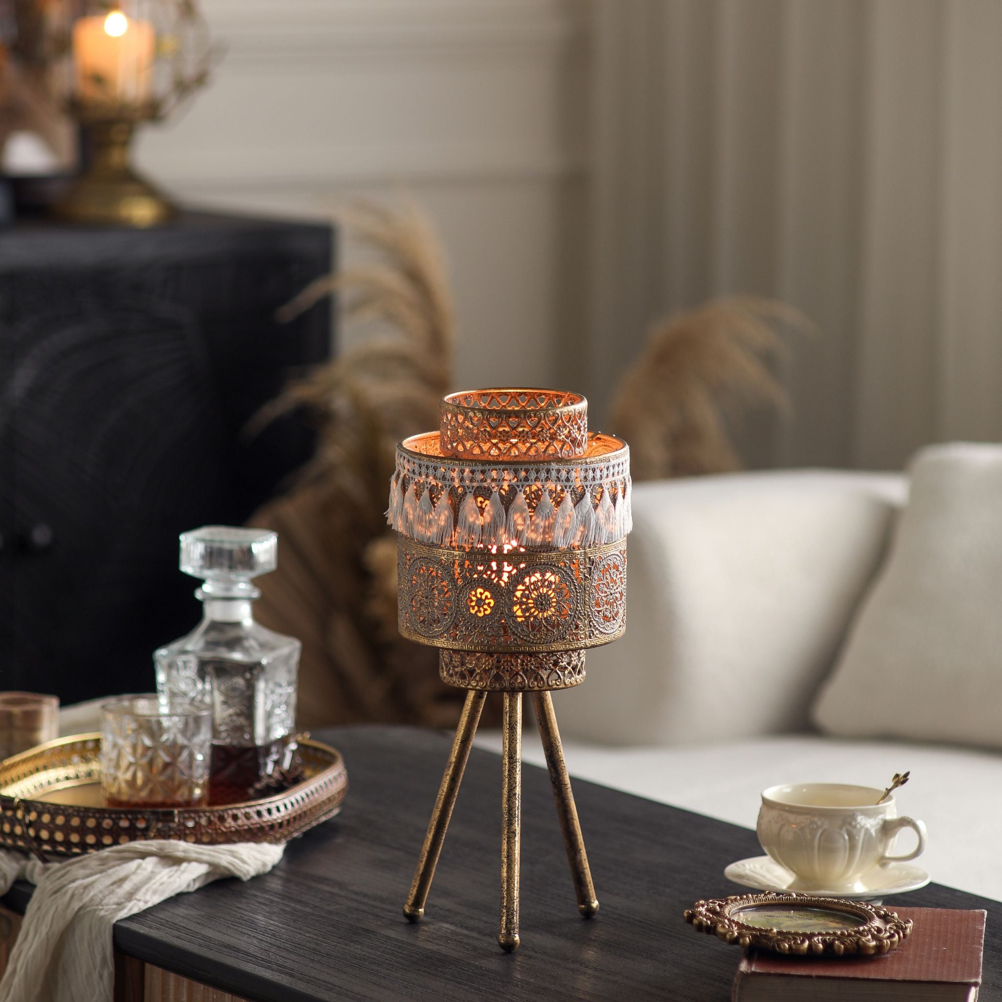 Boho tealight lantern lit, mandala filigree pattern glowing through the antique gold metal body.