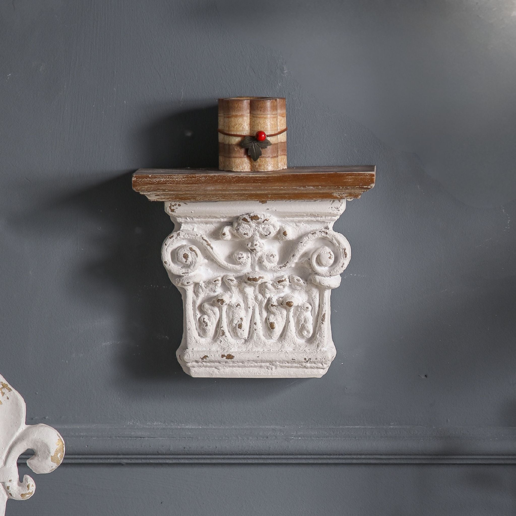 Close-up of Caroline corbel showing the scrolled Corinthian capital detail, central floral motif, and warm timber top shelf