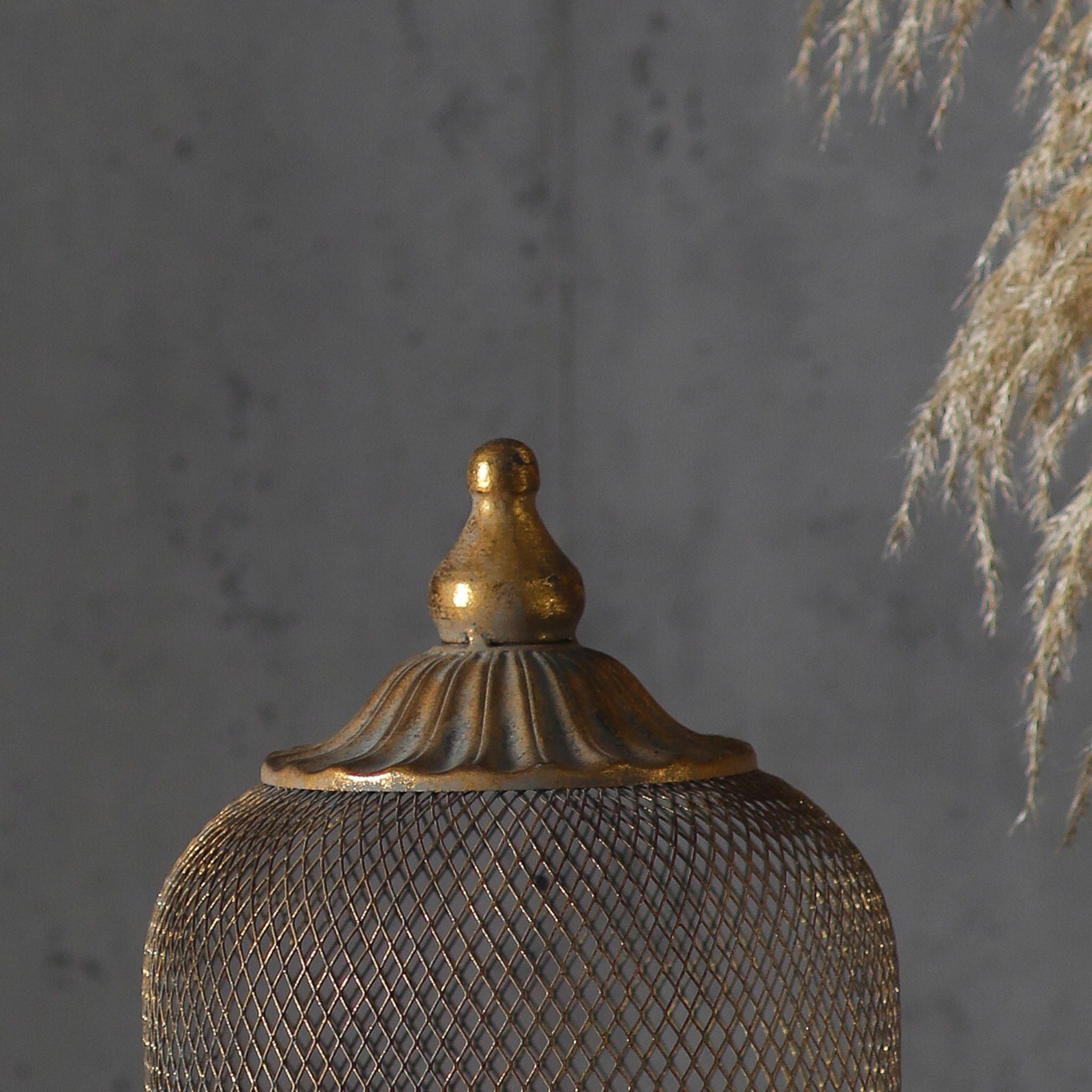 Close-up of the gilded finial and fine diamond mesh at the top of the cloche