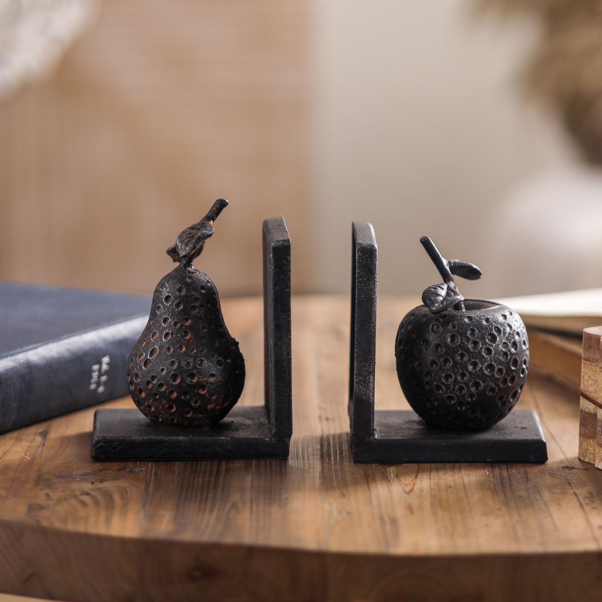 The Poire pear and apple cast iron bookends facing each other, showing both fruit shapes.