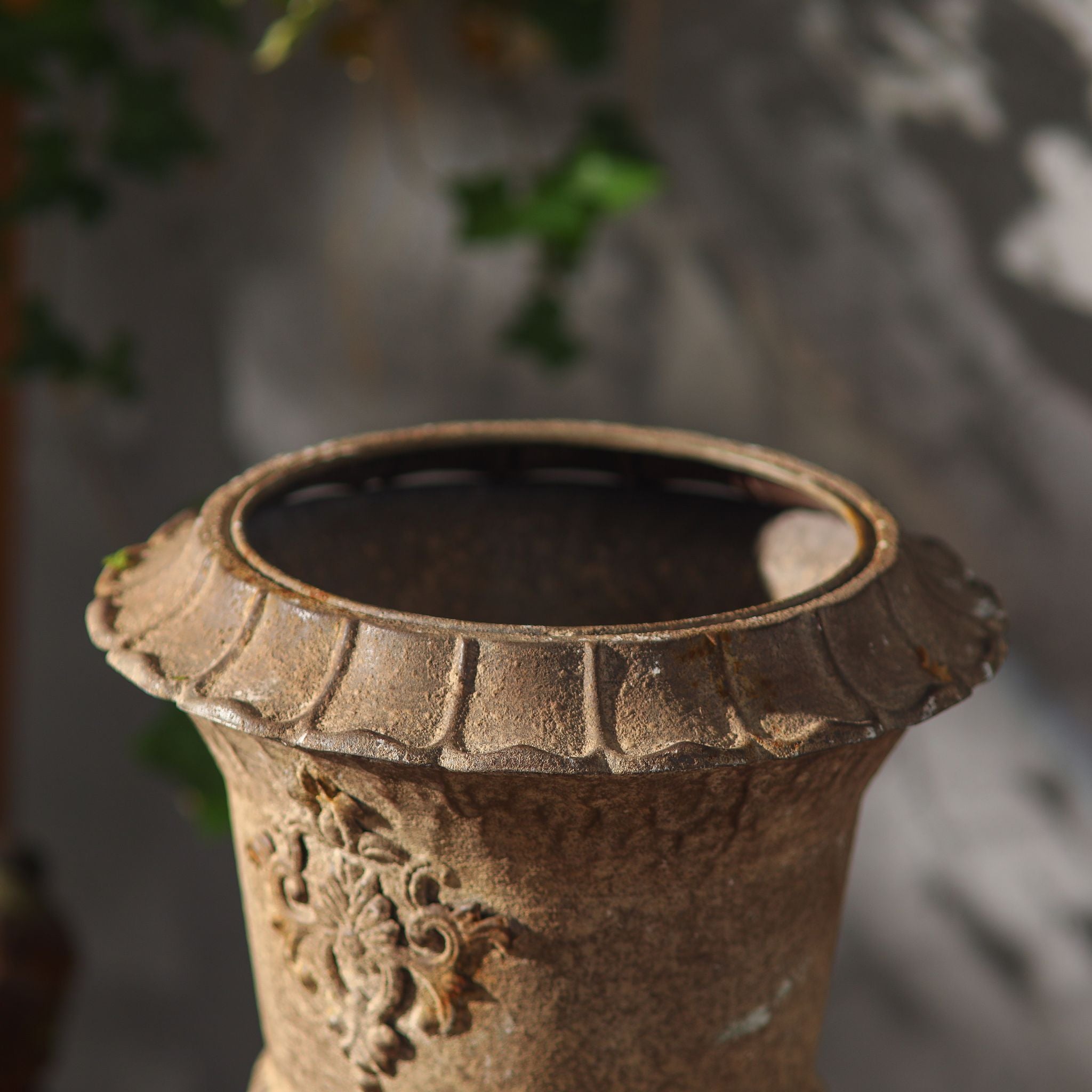 Close-up of the scalloped rim and aged metal finish on the Delphine urn