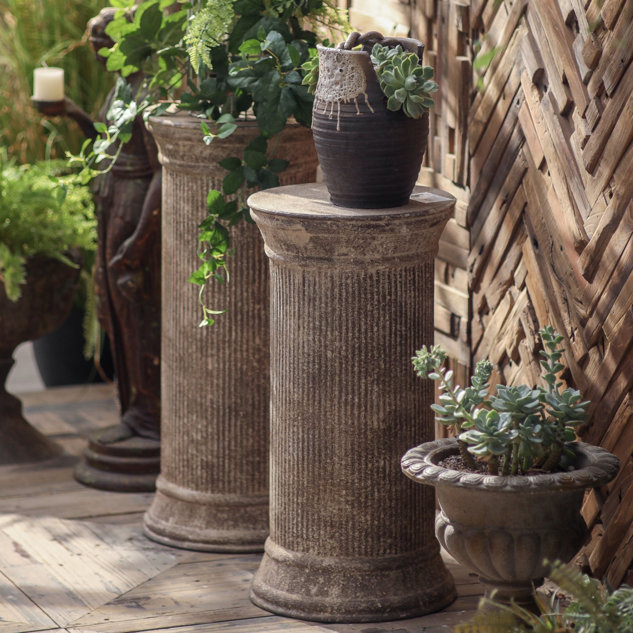 Celeste column pedestal topped with a glazed vessel and trailing succulents as a plant stand.