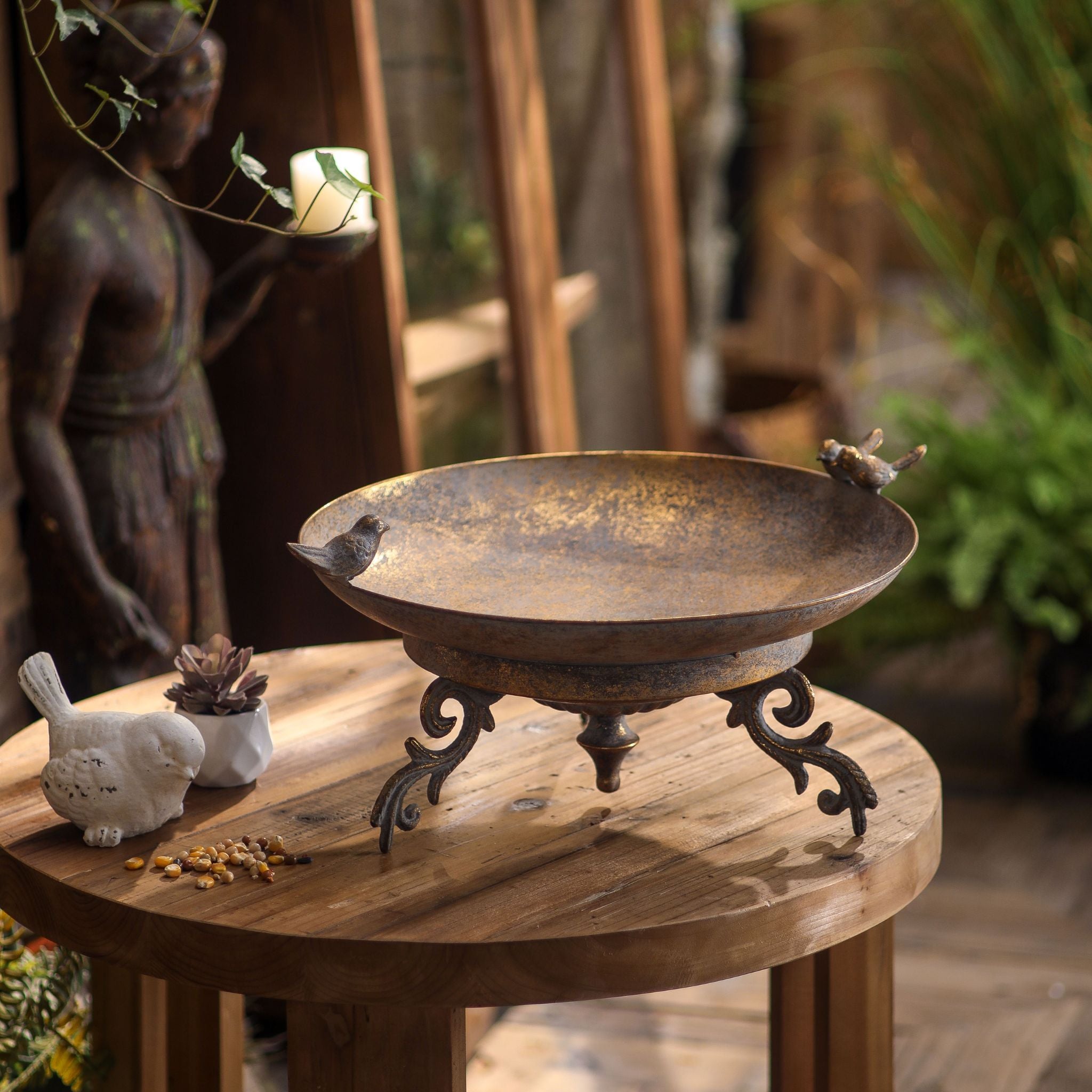 Chandler bird feeder dish from above, showing the shallow bronze and gold bowl and the scrolled footed base.