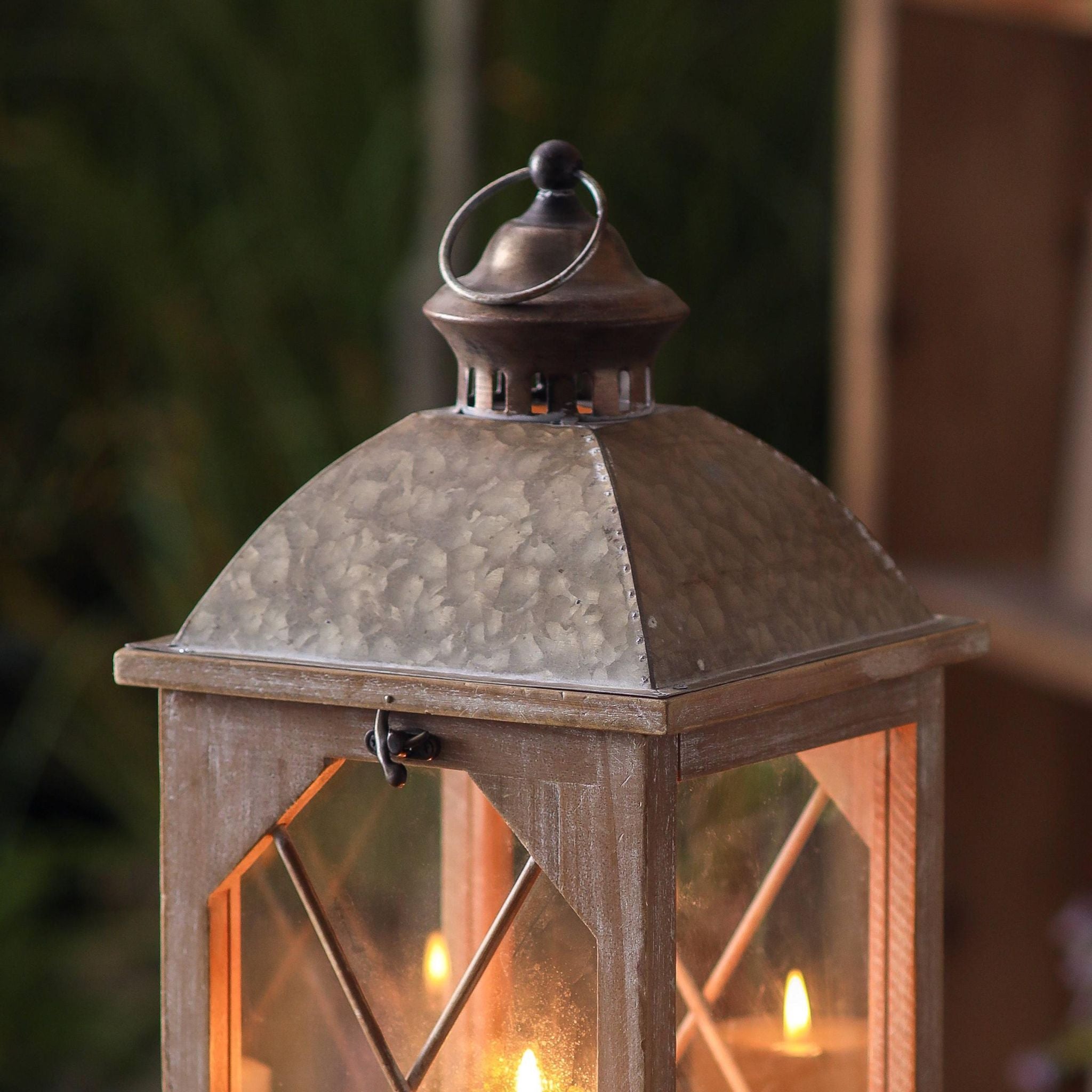 Close-up of hammered galvanised metal dome and ring handle on a wood lantern