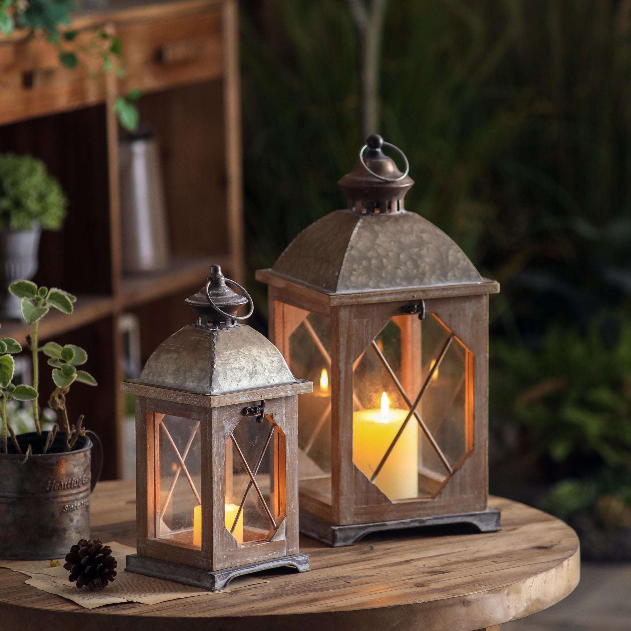 Whitewashed wood lantern with galvanised metal top and a glowing pillar candle