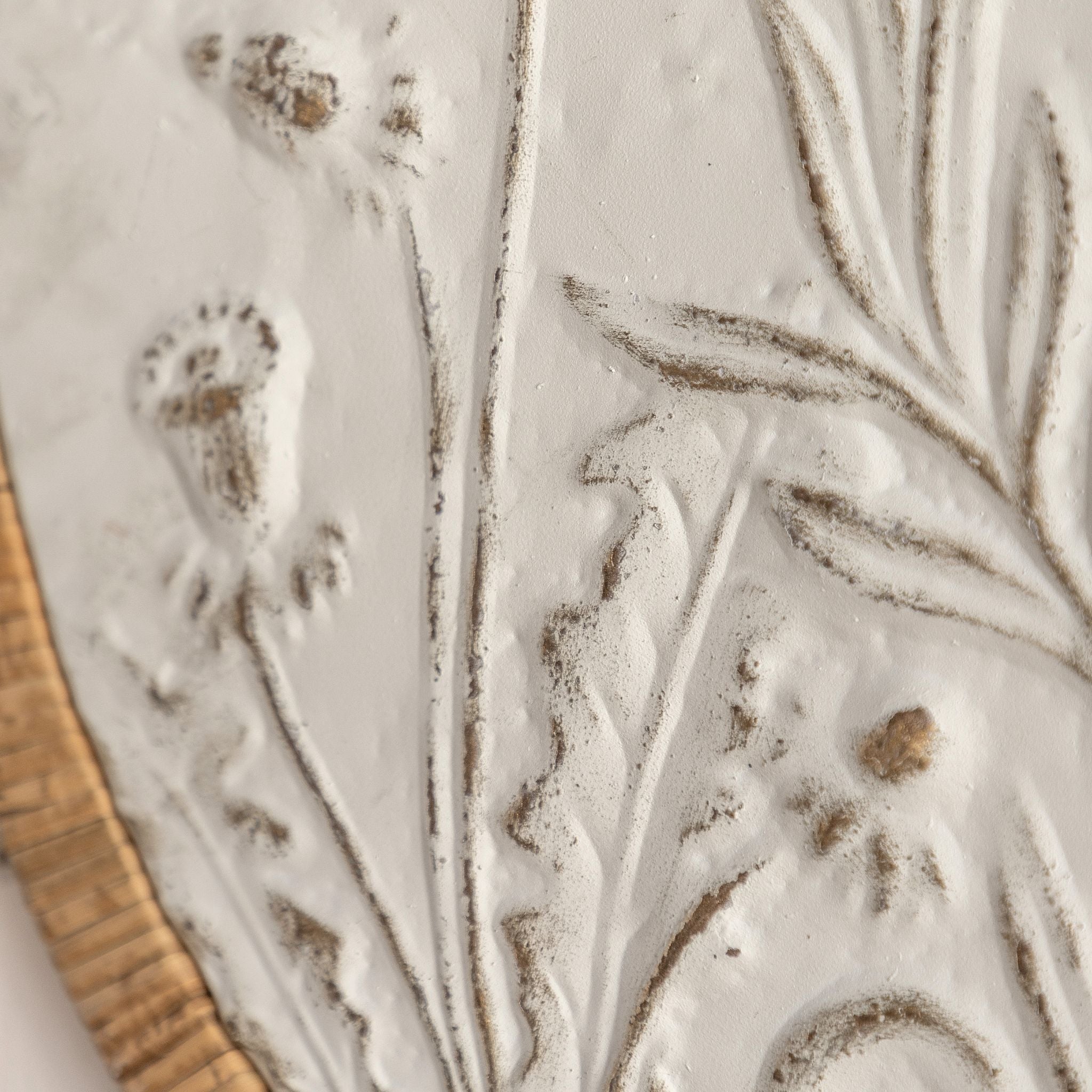 Detail of the embossed wildflower relief and the rattan-wrapped frame of the Dumas panel.