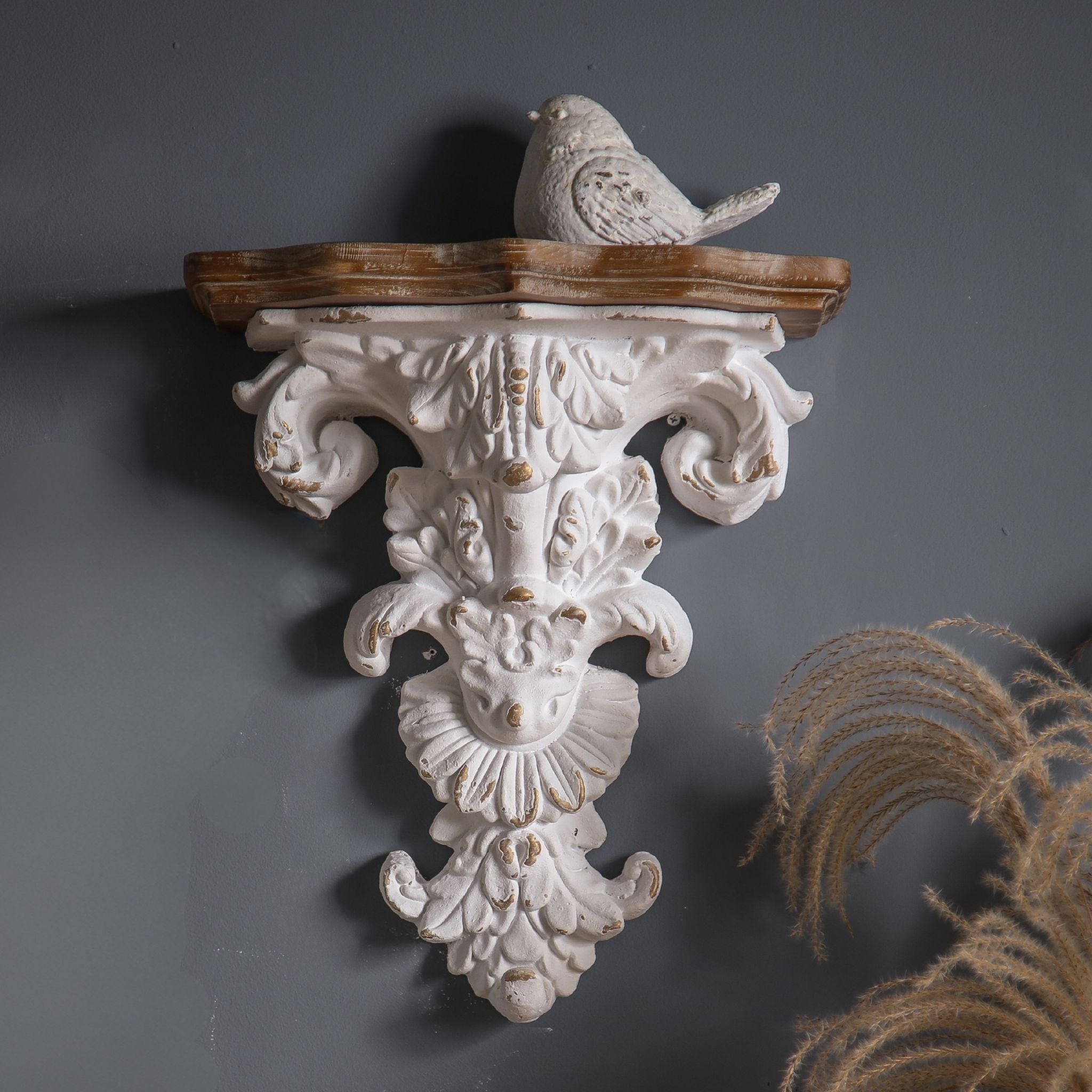 Elise French Provincial tall wall corbel shelf in distressed whitewash with carved acanthus scrolls and timber top, mounted solo on a charcoal wall with a small white bird on top. Hero