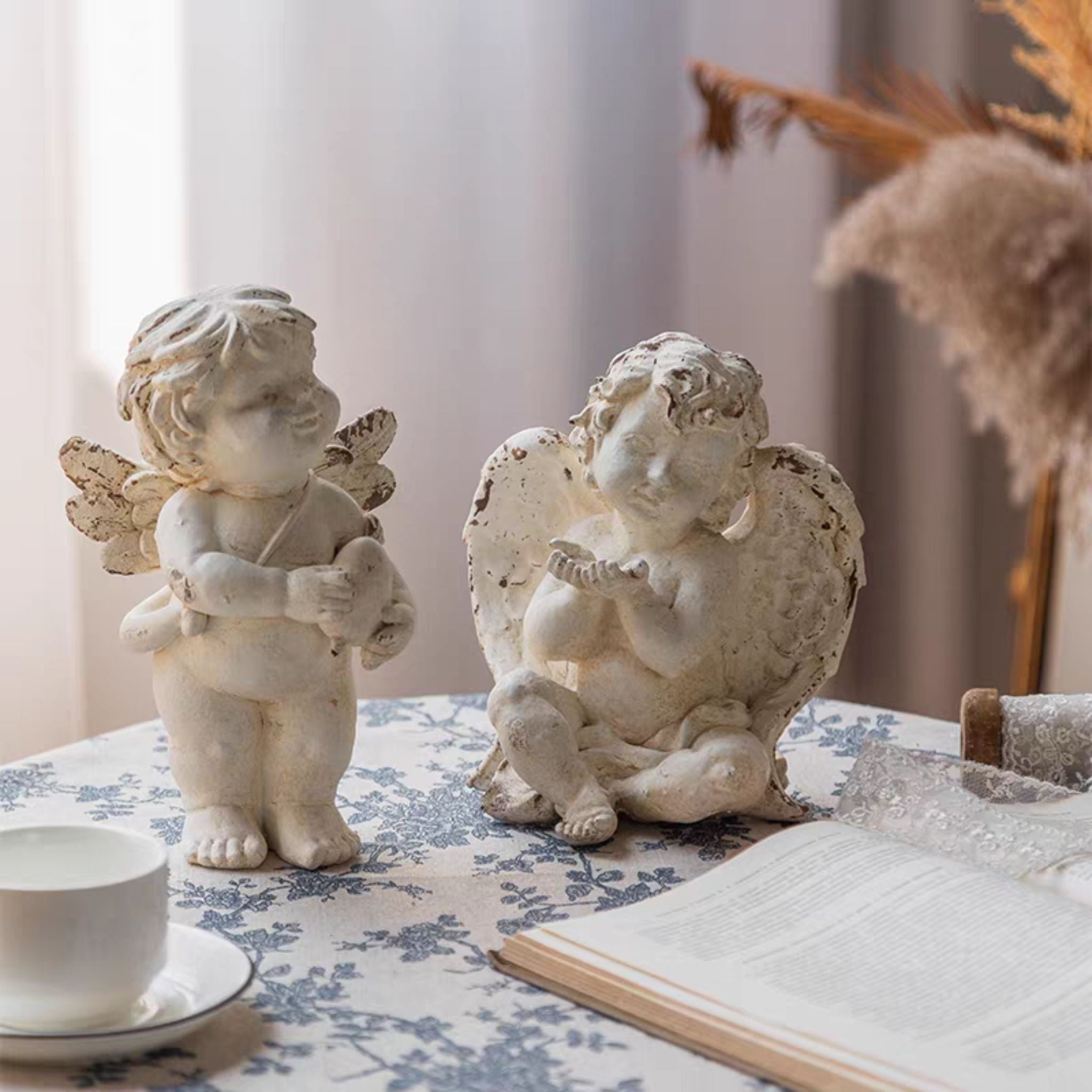 Élodie cherub figurine shown alongside a second standing cherub, styling reference